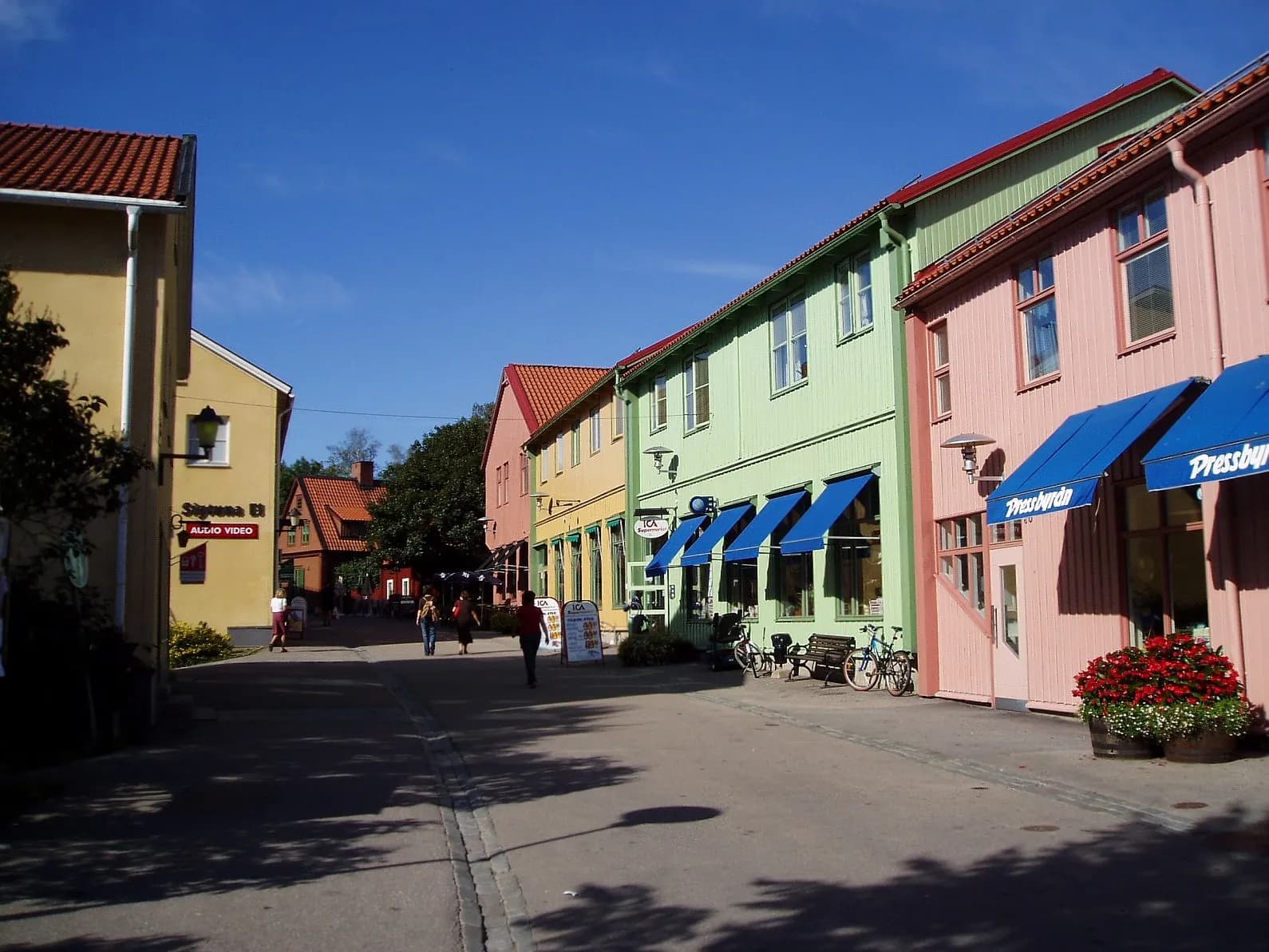 Stora gatan à Sigtuna, rue bordée de maisons colorées aux auvents bleus