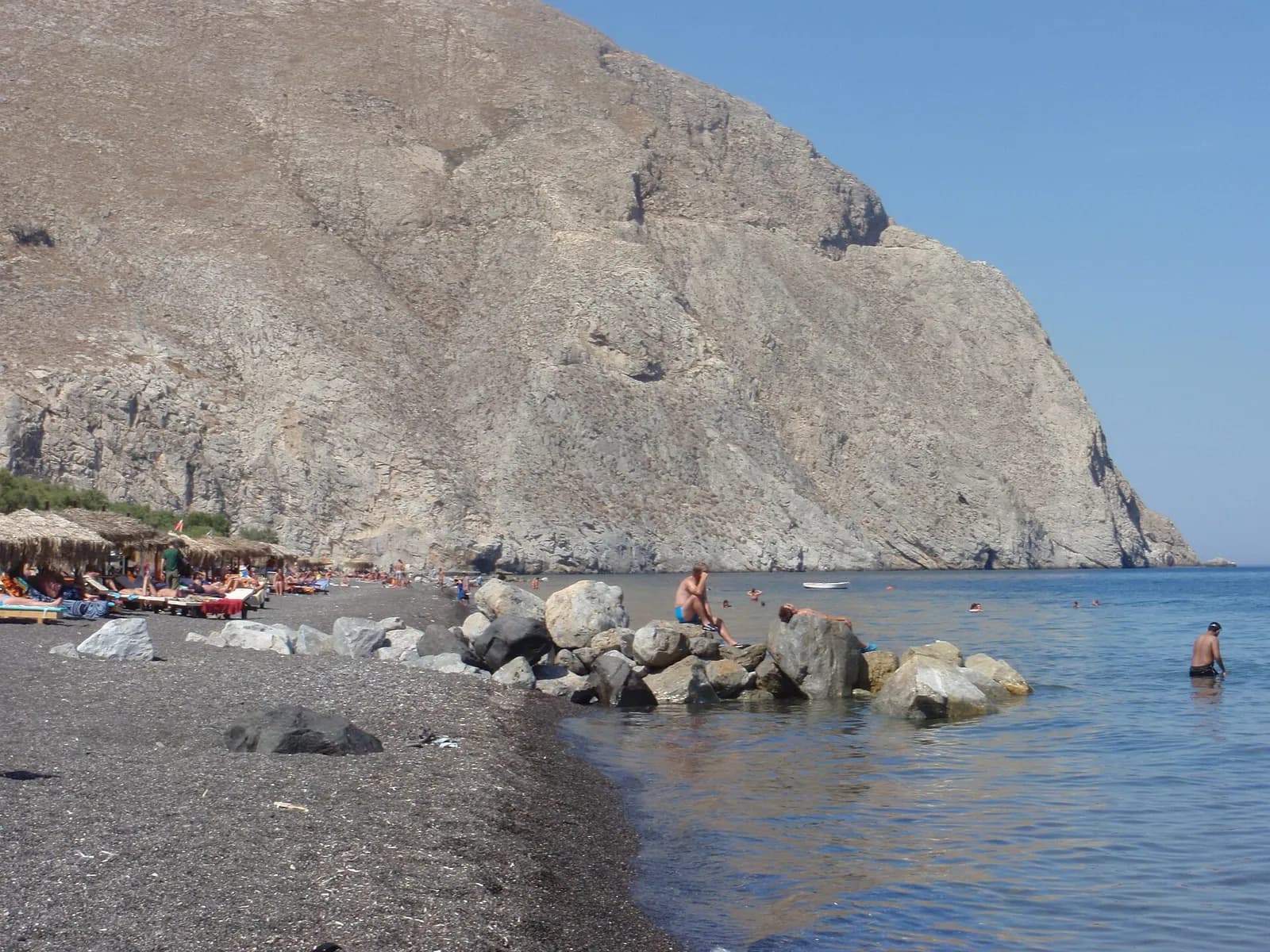 rocks and black volcanic sand on Perissa beach, beneath Mesa Vouno