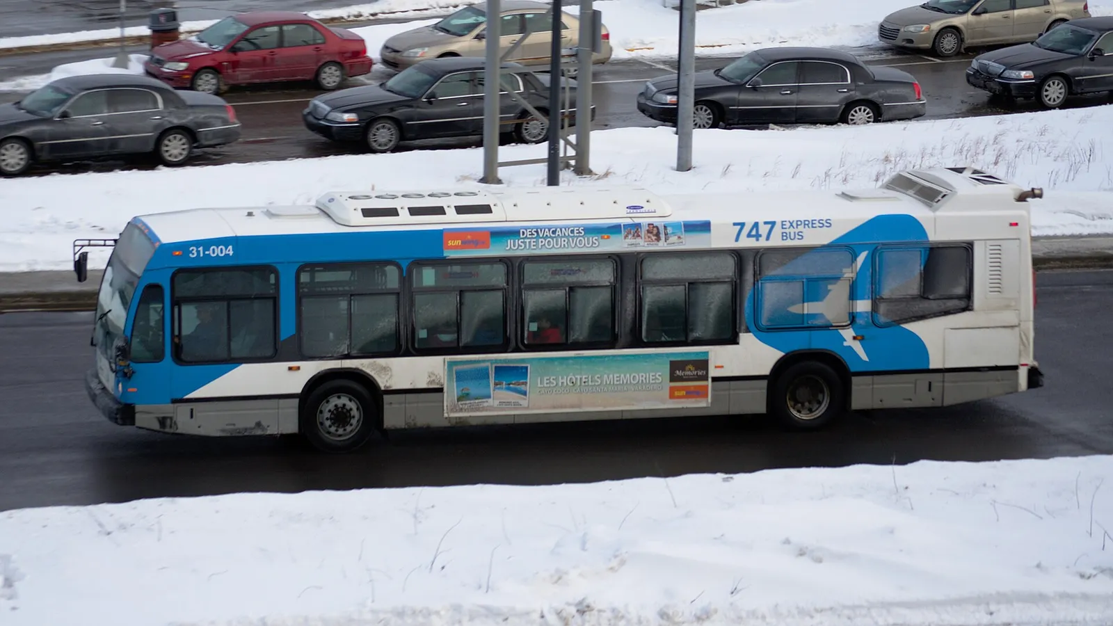 bus 747 Express circulant devant l'aéroport de Montréal un jour de neige