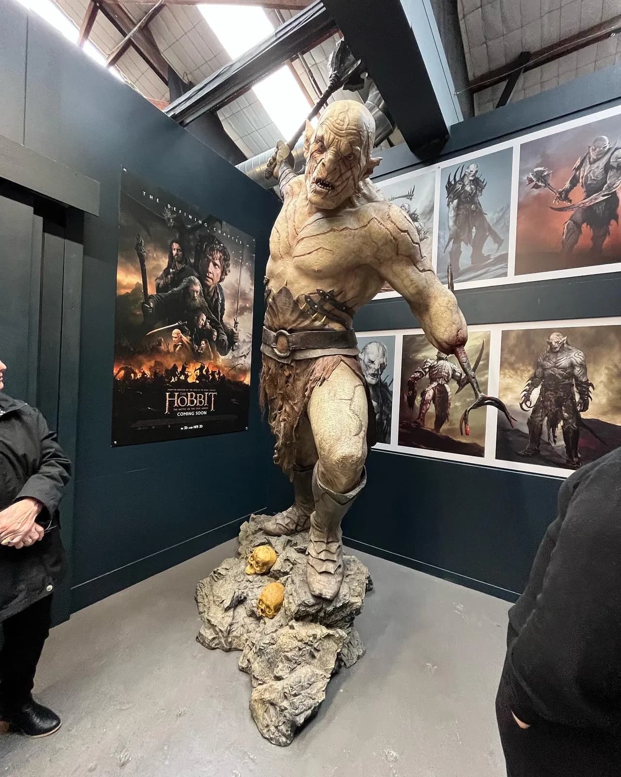 une sculpture d'orc entourée de dessins conceptuels exposés chez Weta Workshop
