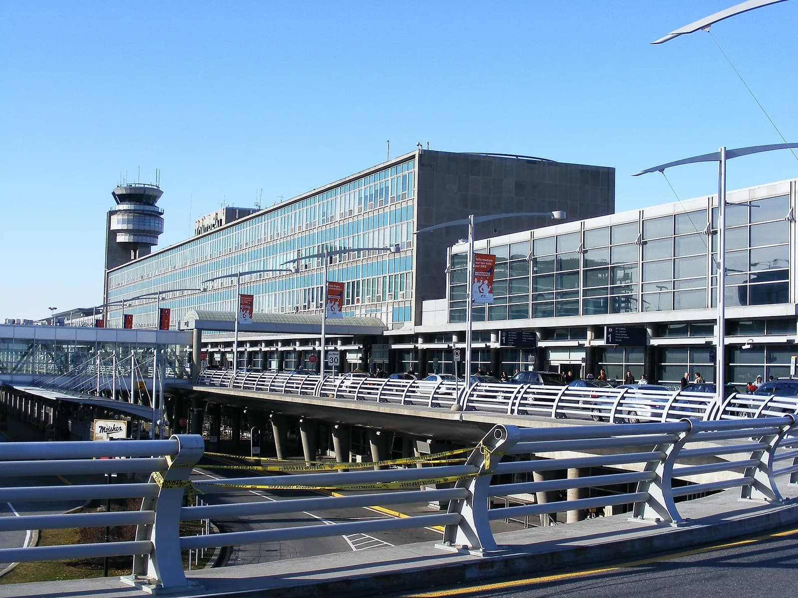 façade vitrée de l'aéroport Montréal-Trudeau avec sa tour de contrôle et ses passerelles