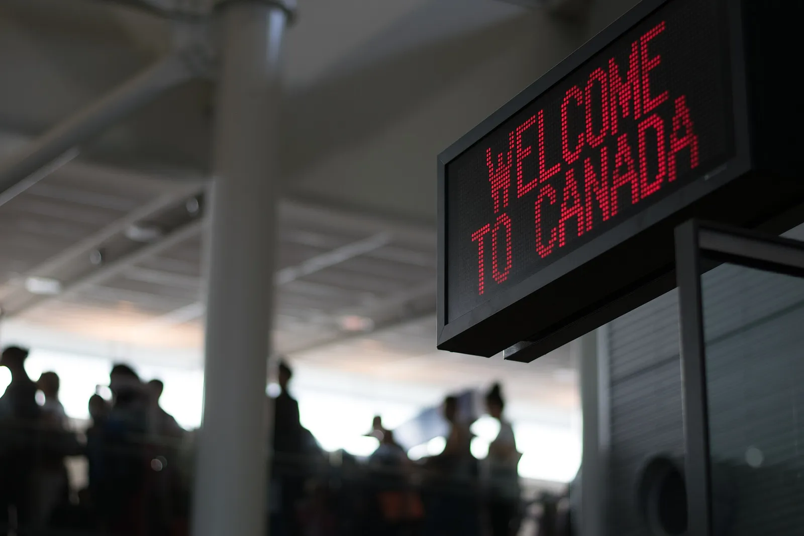 panneau lumineux « Welcome to Canada » au passage de la frontière à l'aéroport de Montréal