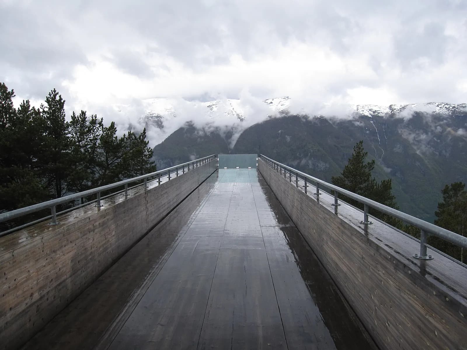 la passerelle de Stegastein mouillée par la pluie, entre les pins, face au fjord