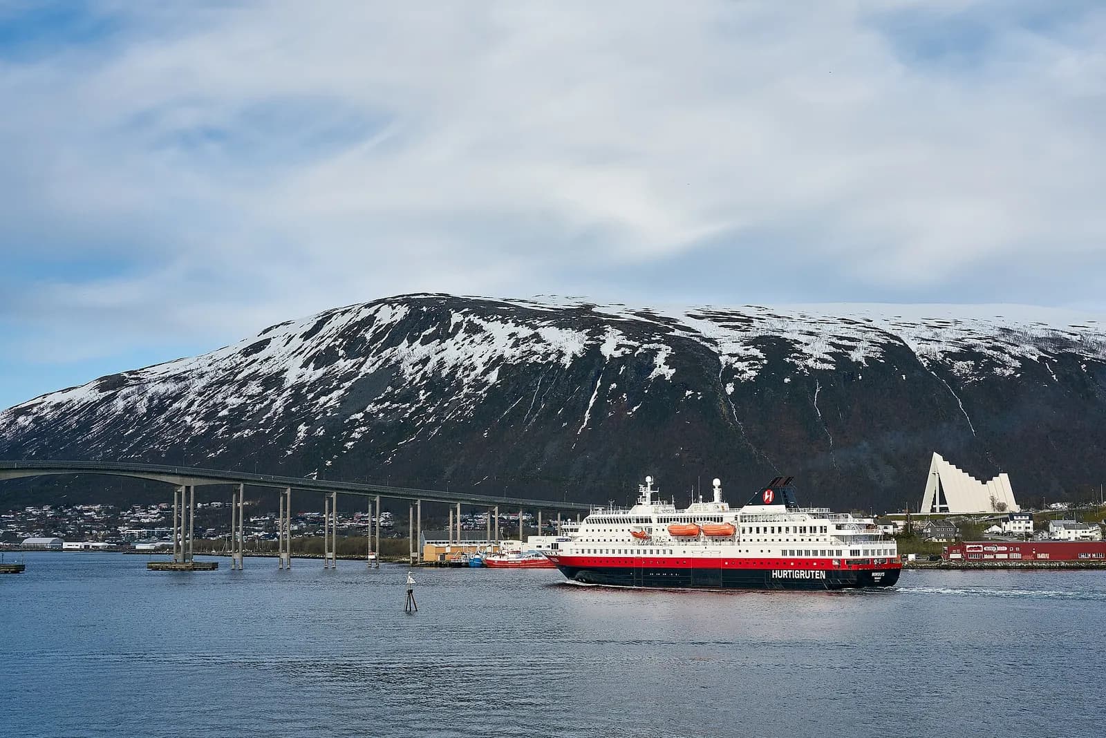 navire Hurtigruten Nordlys approchant du pont de Tromsø et de la cathédrale arctique