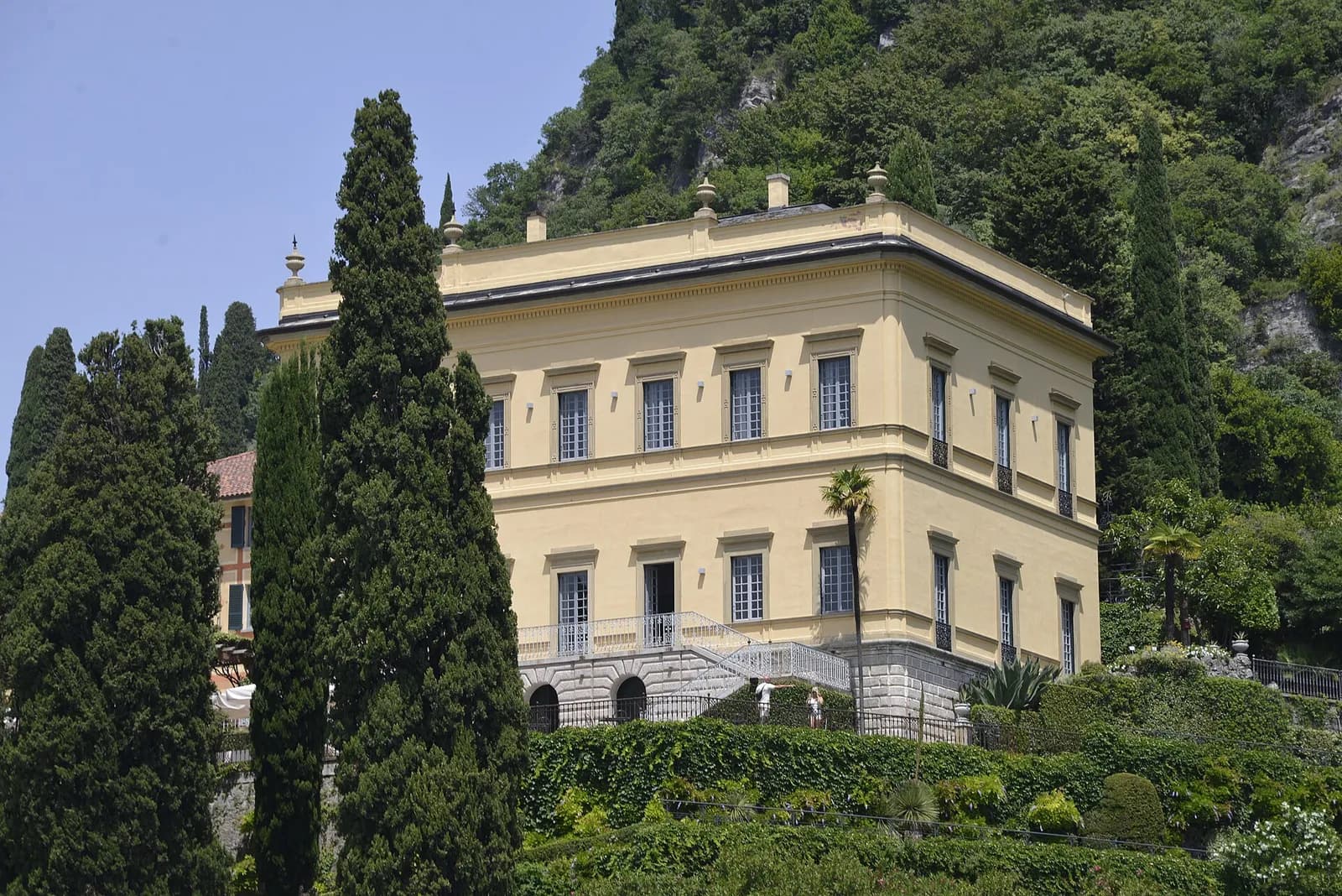 la façade jaune de la Villa Cipressi entre les cyprès, au-dessus du lac de Côme