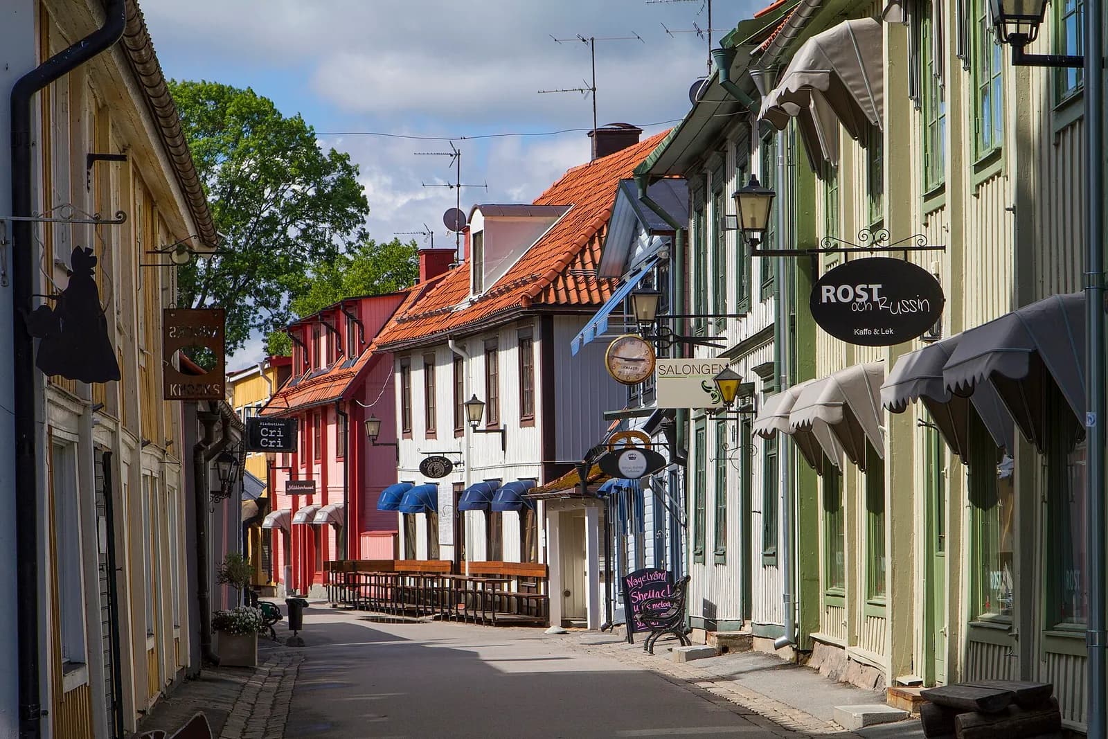Stora gatan, rue piétonne de Sigtuna bordée de maisons en bois et d'enseignes