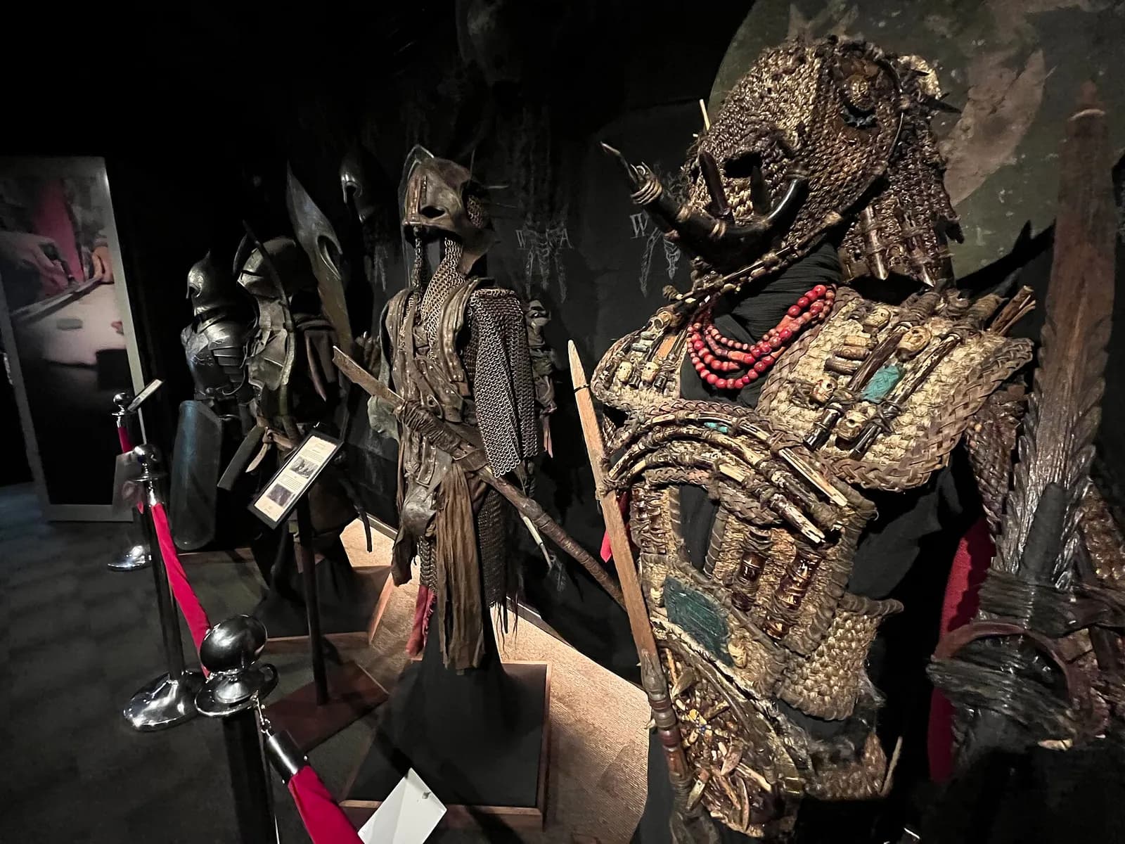 des armures et costumes de films exposés dans une salle sombre de Weta Workshop