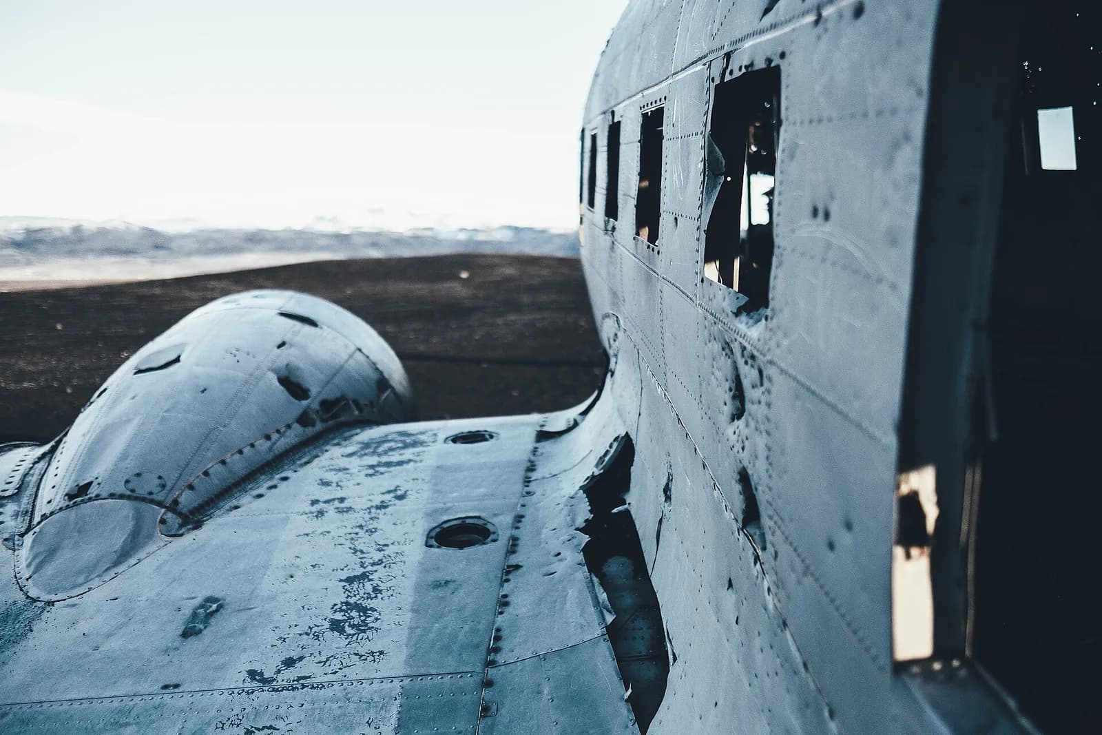 détail de l'aile et des hublots de l'épave d'avion de Sólheimasandur dans la lumière froide
