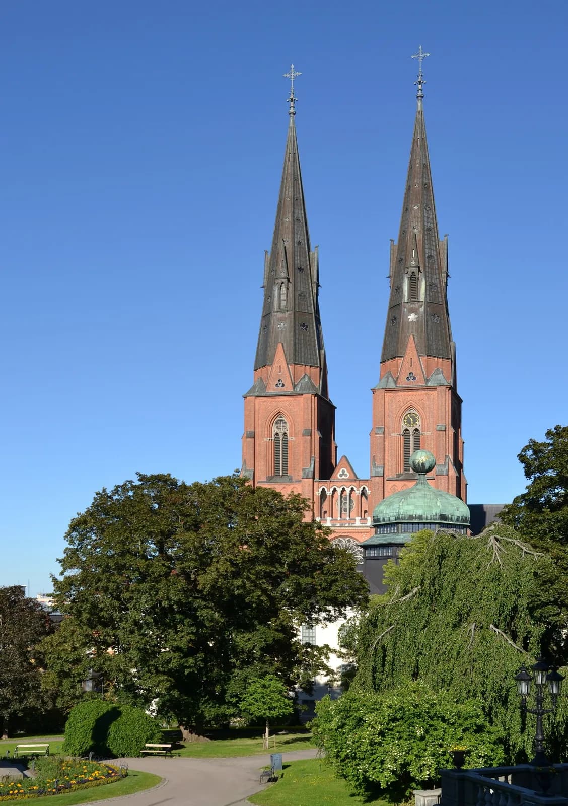 les deux flèches de la cathédrale d'Uppsala en brique rouge sous un ciel bleu