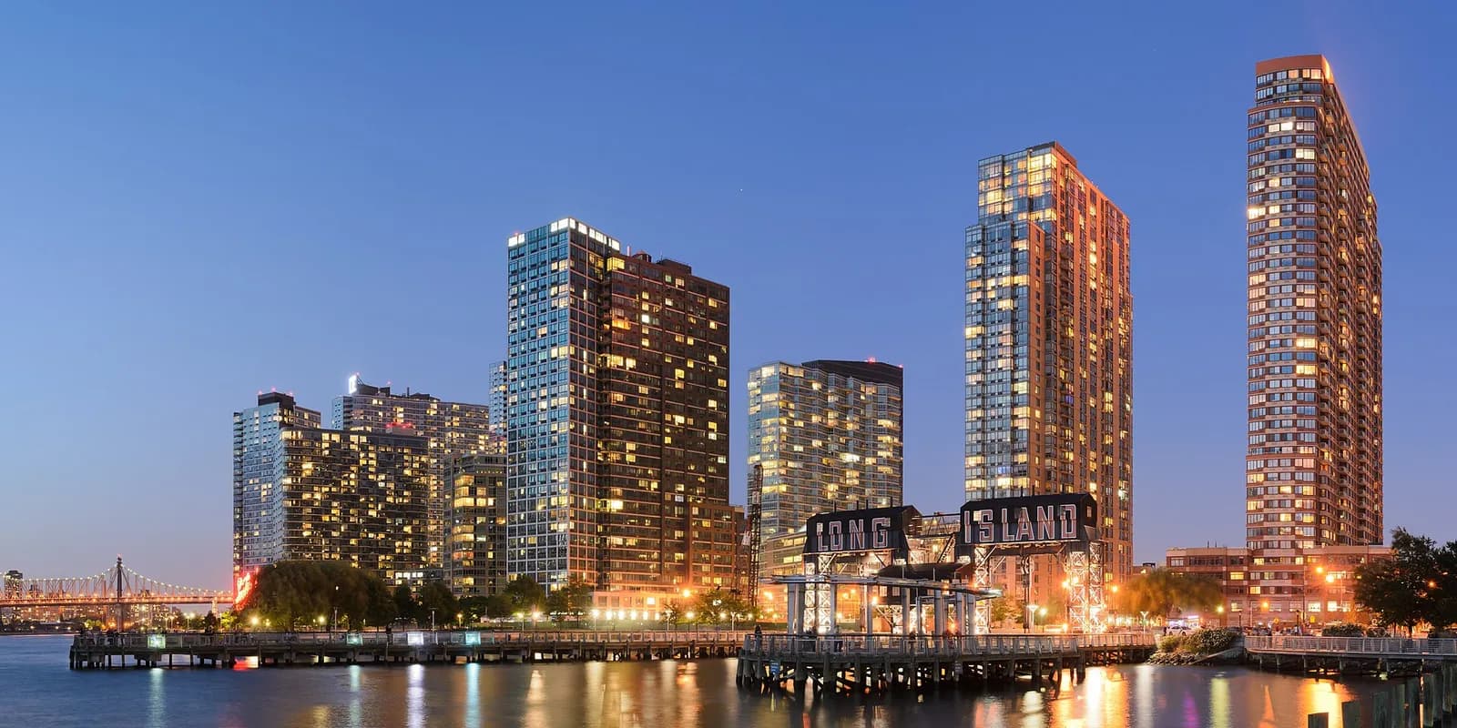 Long Island City towers and the Gantry Plaza sign lit up at dusk