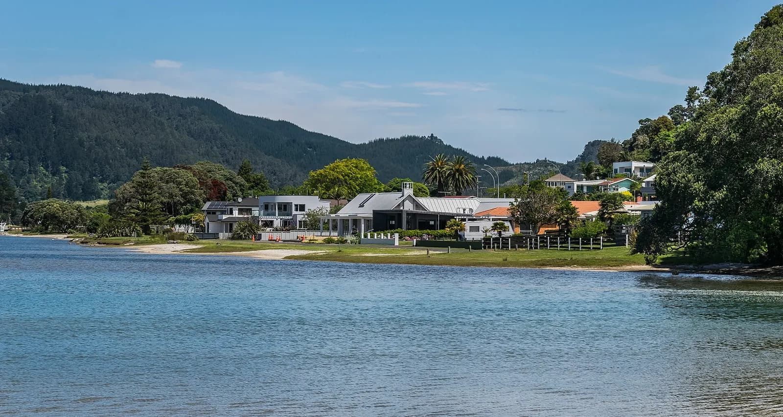 des maisons au bord de l'eau le long du port de Tairua, sur la péninsule de Coromandel