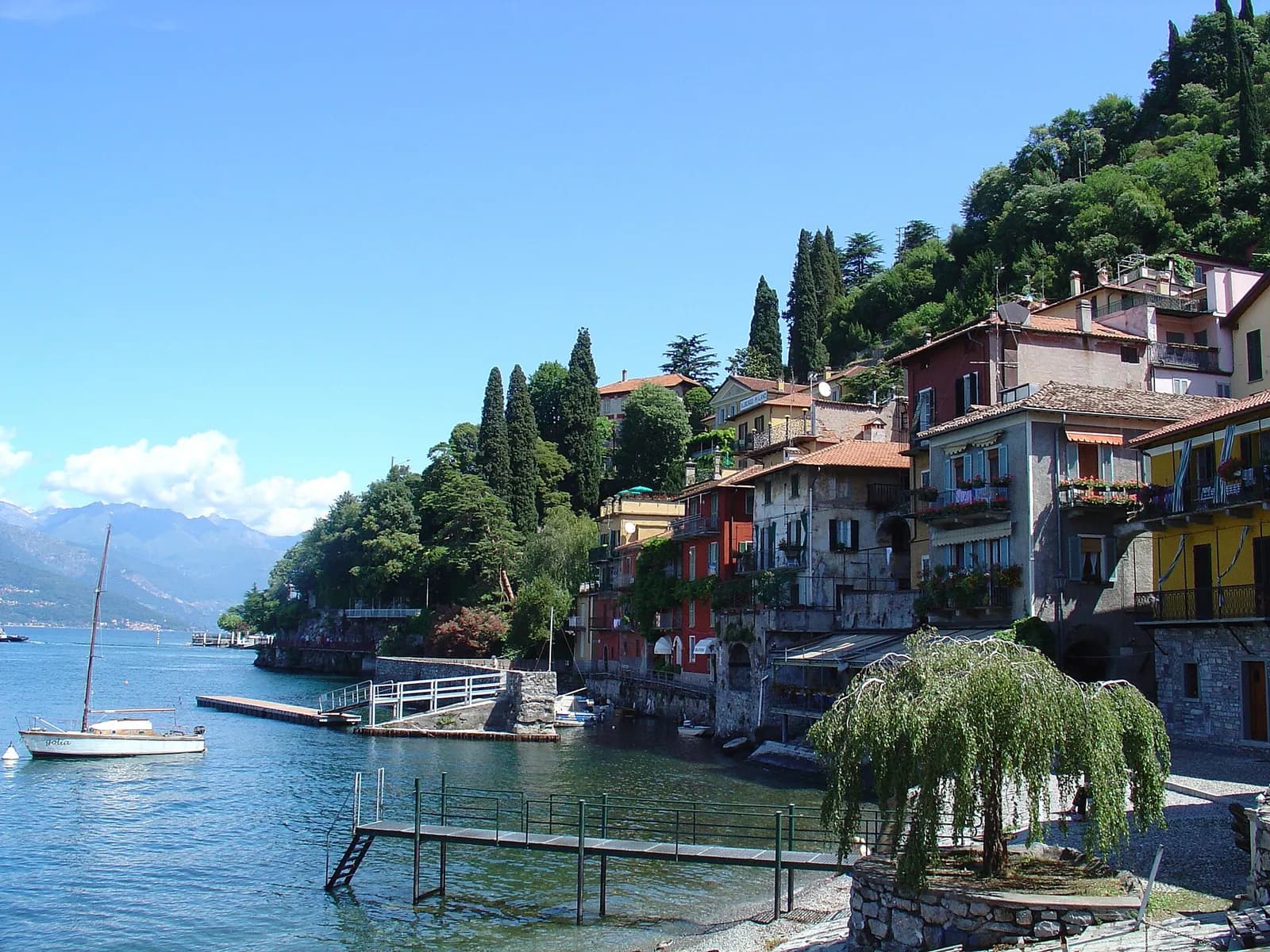 ponton et saule pleureur devant les maisons colorées de Varenna sur le lac de Côme