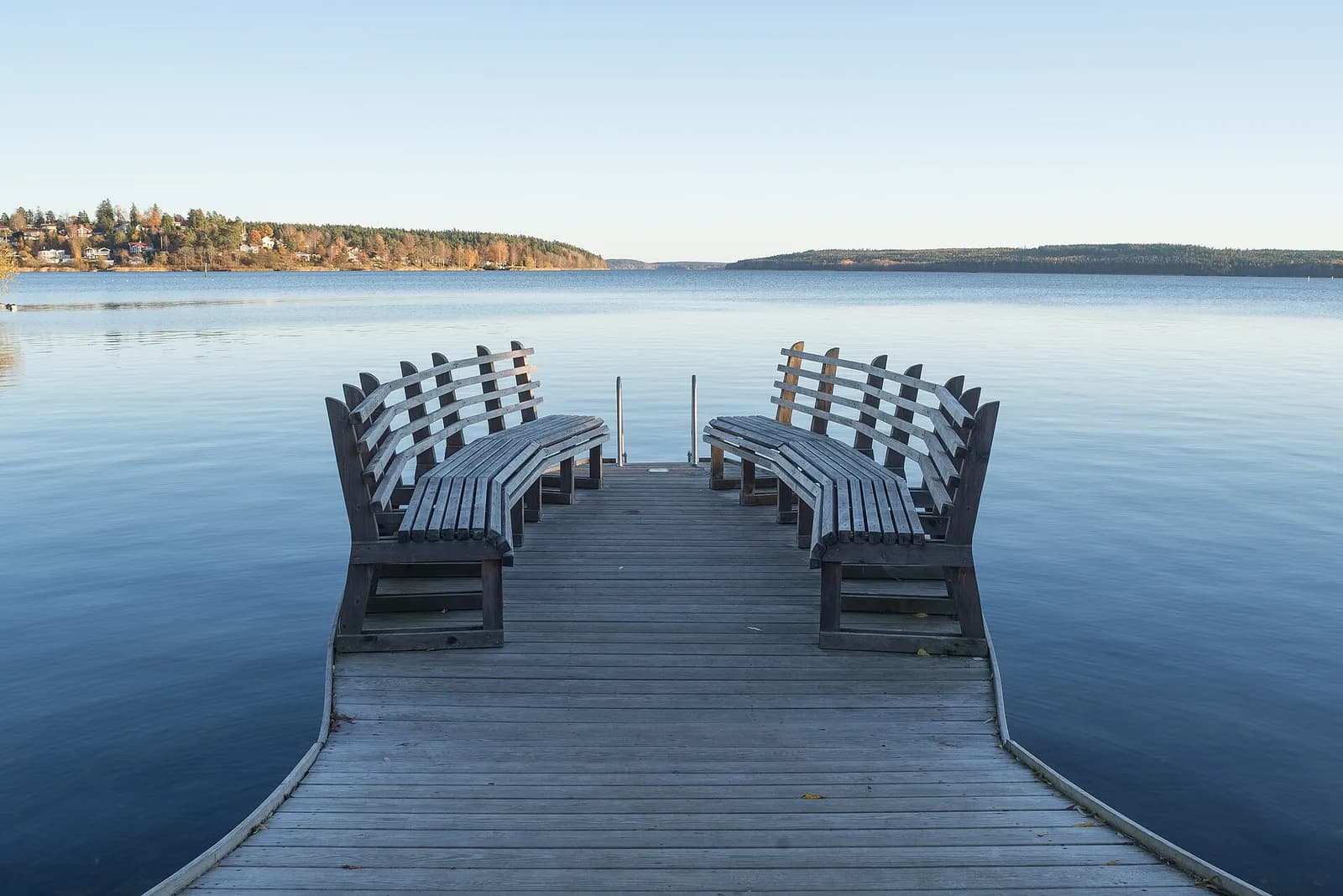 ponton en bois et bancs face aux eaux calmes du lac Mälaren à Sigtuna