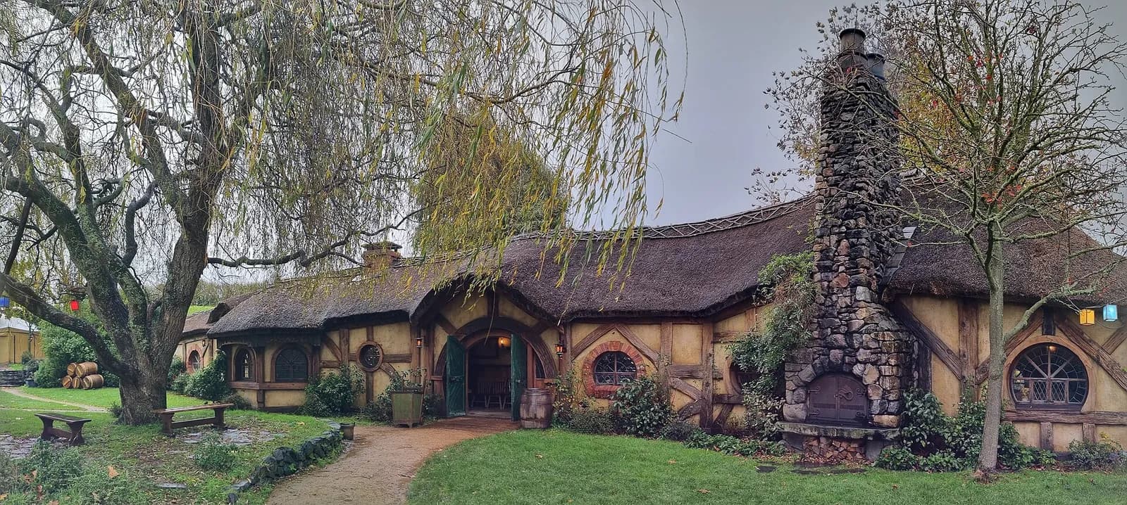 des maisons de hobbits au toit de chaume et leur grande cheminée en pierre à Hobbiton