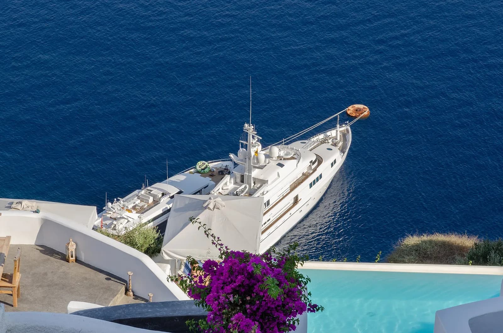 a pool framed by bougainvillea overlooking the caldera in Oia