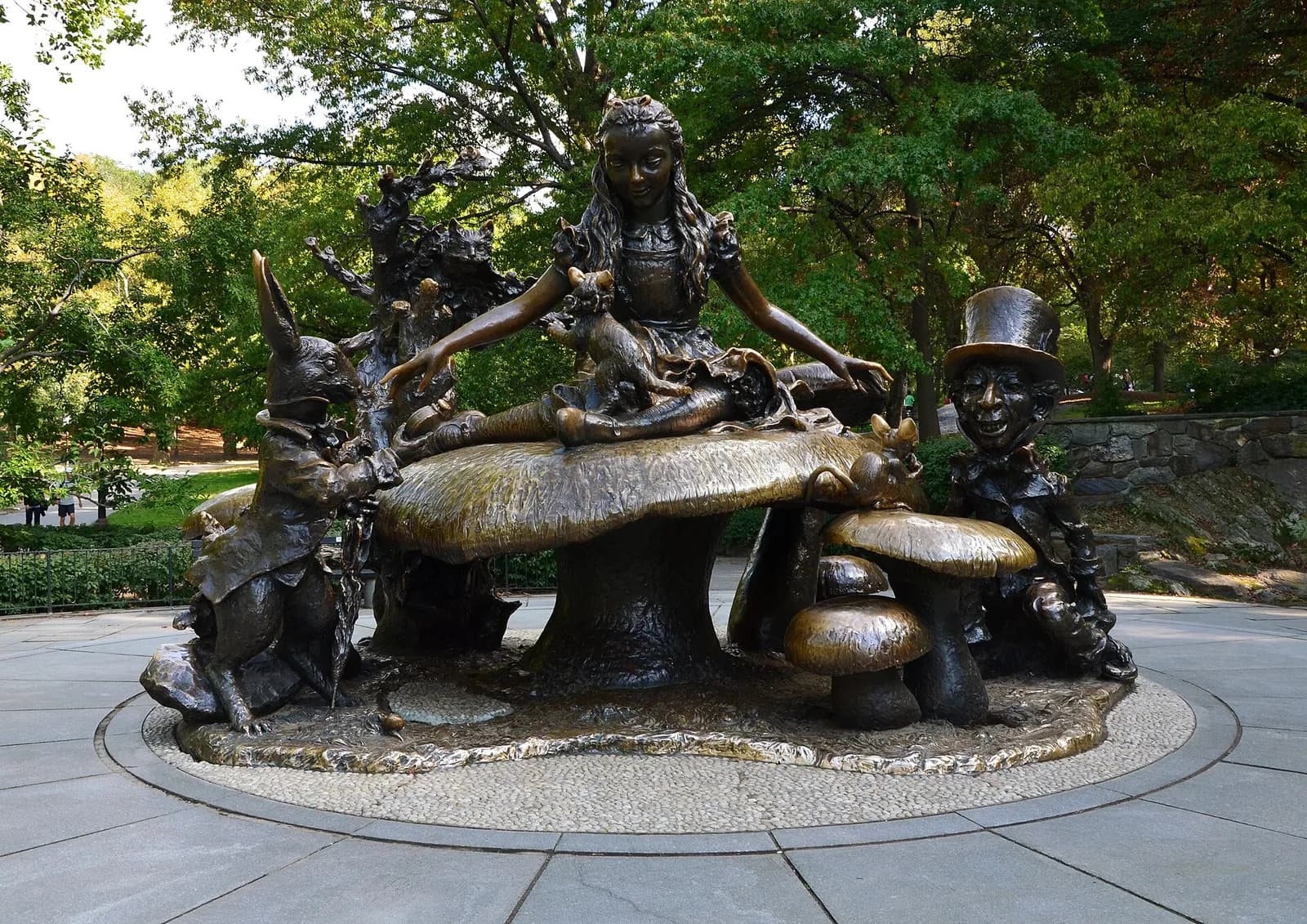 la sculpture en bronze d'Alice au pays des merveilles assise sur un champignon géant