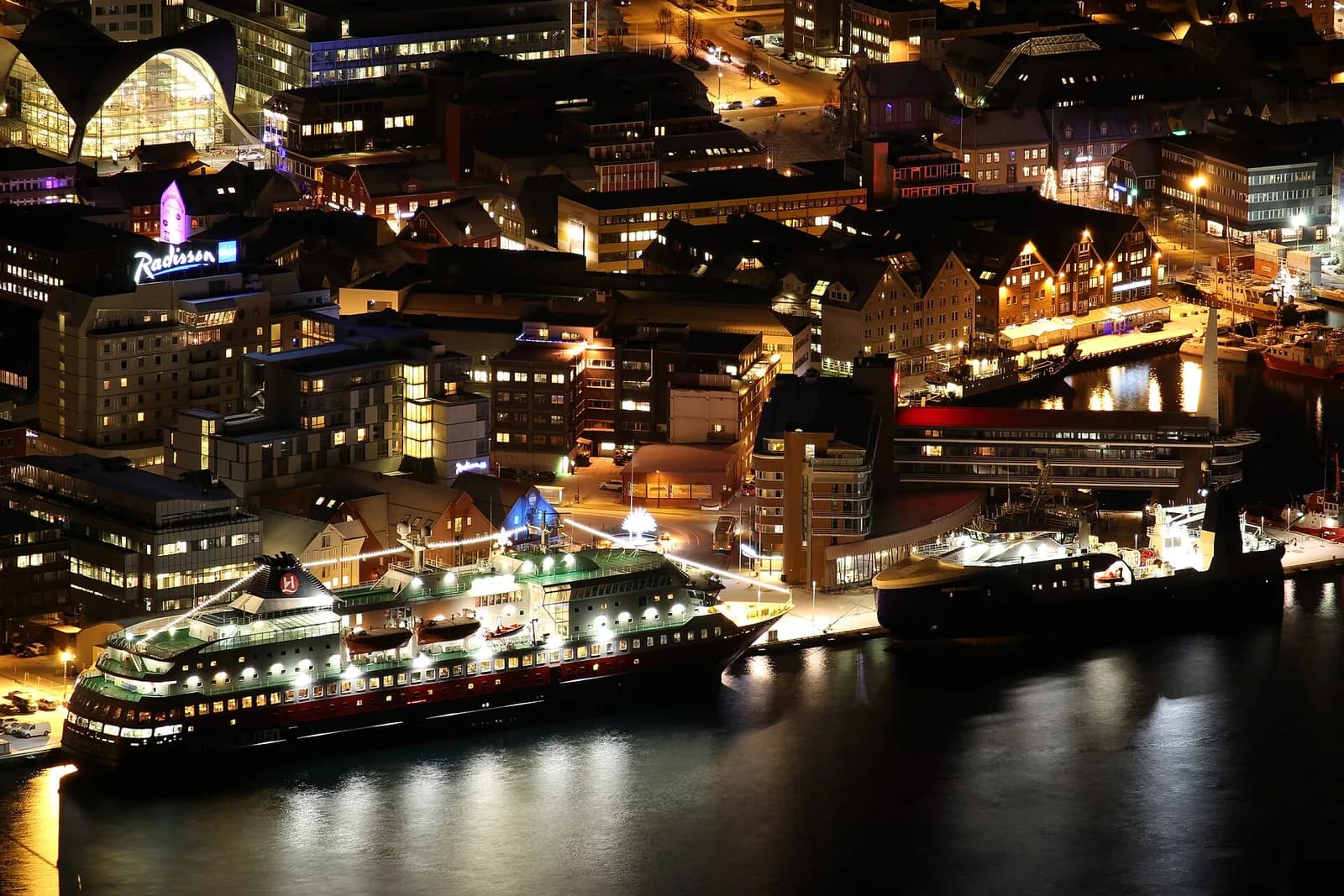 quais de Tromsø illuminés la nuit avec un navire Hurtigruten à quai