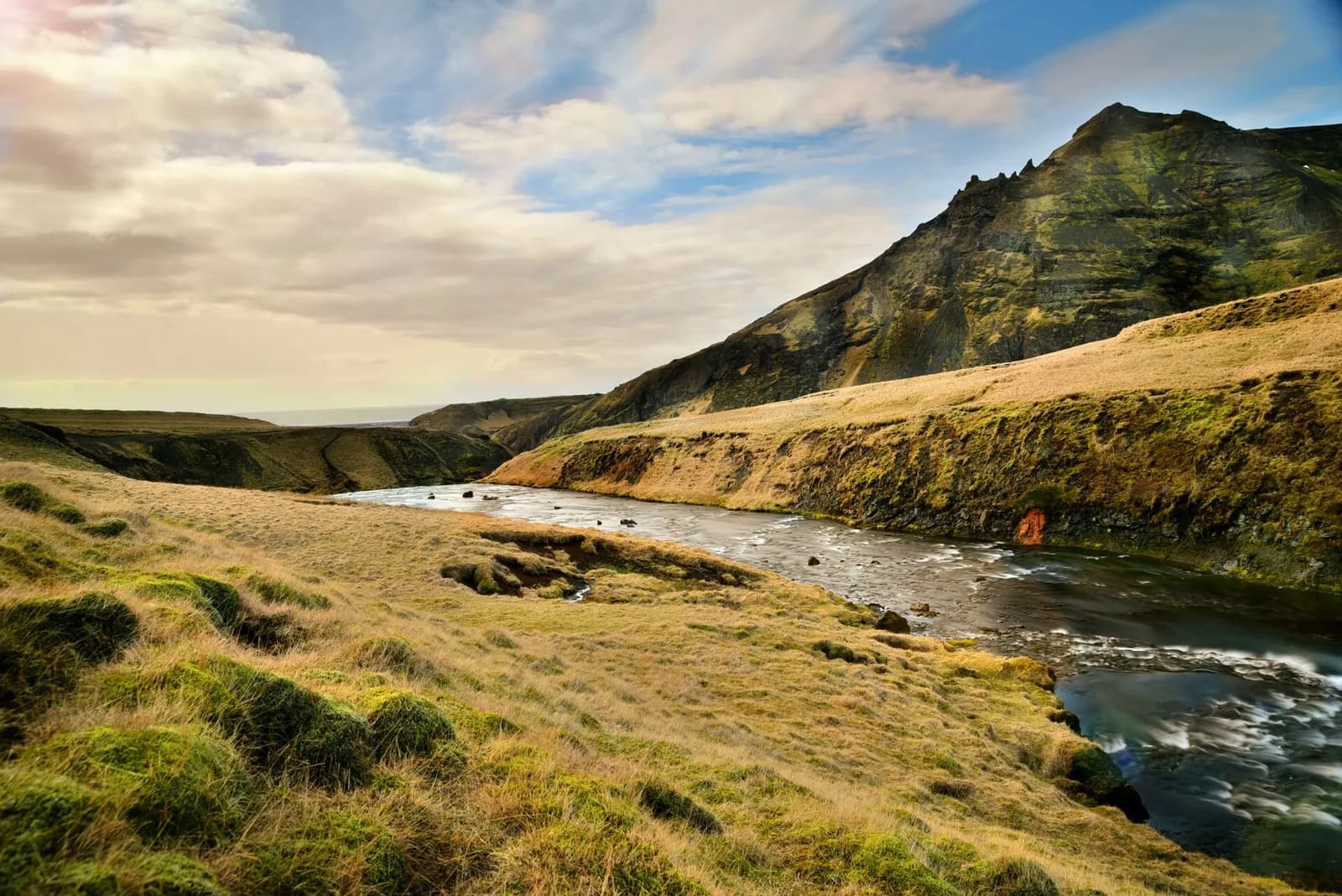 rivière serpentant au fond d'une vallée verdoyante d'Islande