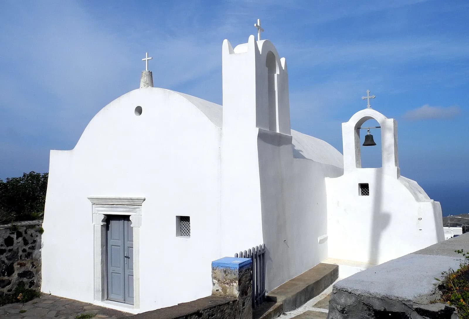 the white Agia Sofia church with its bell gable in the village of Firostefani
