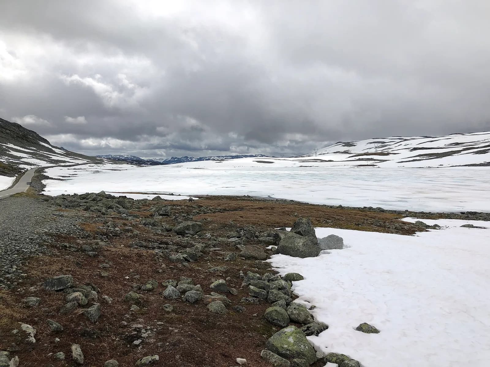paysage minéral d'Aurlandsfjellet où la neige persiste au bord de la route