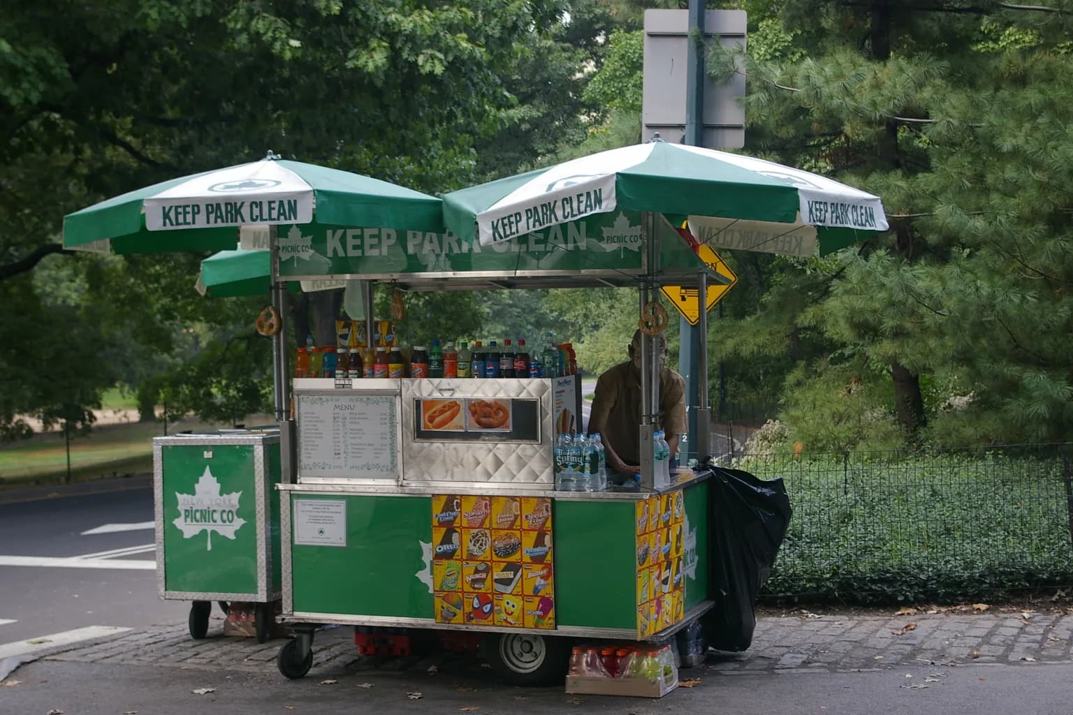 kiosque de vente de hot-dogs, glaces et boissons sous parasols verts dans Central Park