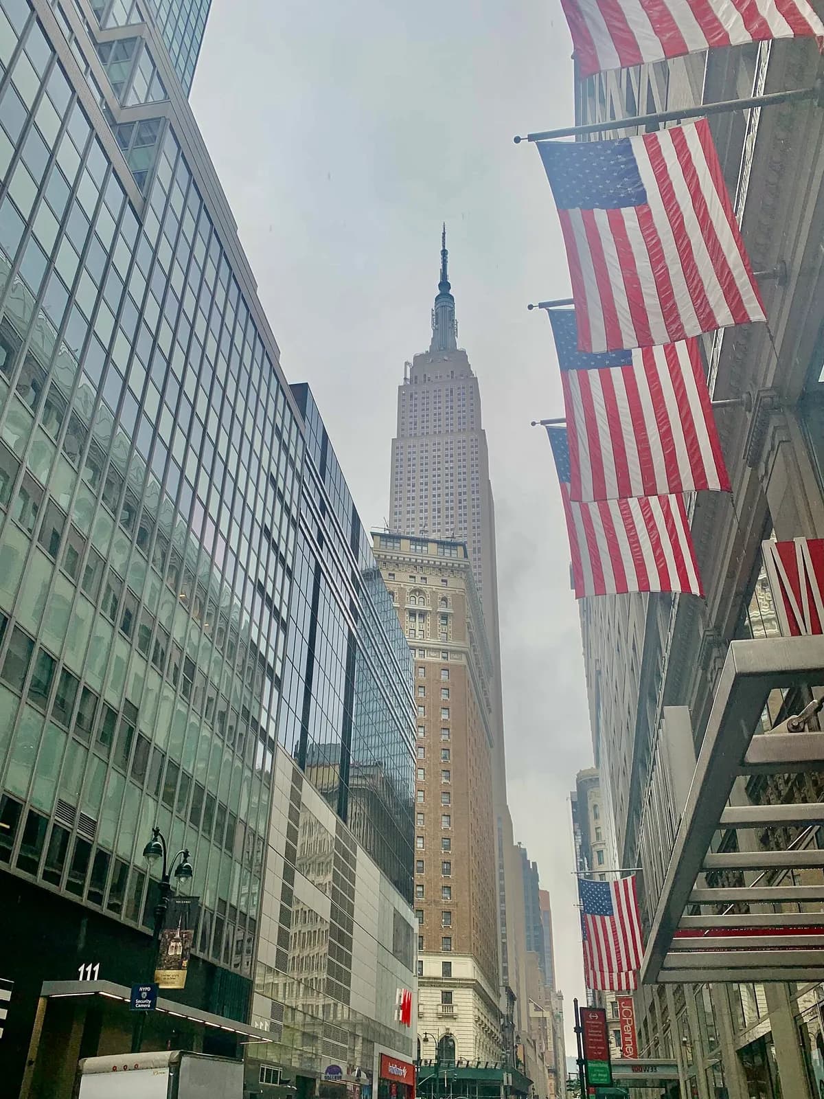 l'Empire State Building se dressant au bout d'une rue de Midtown pavoisée de drapeaux