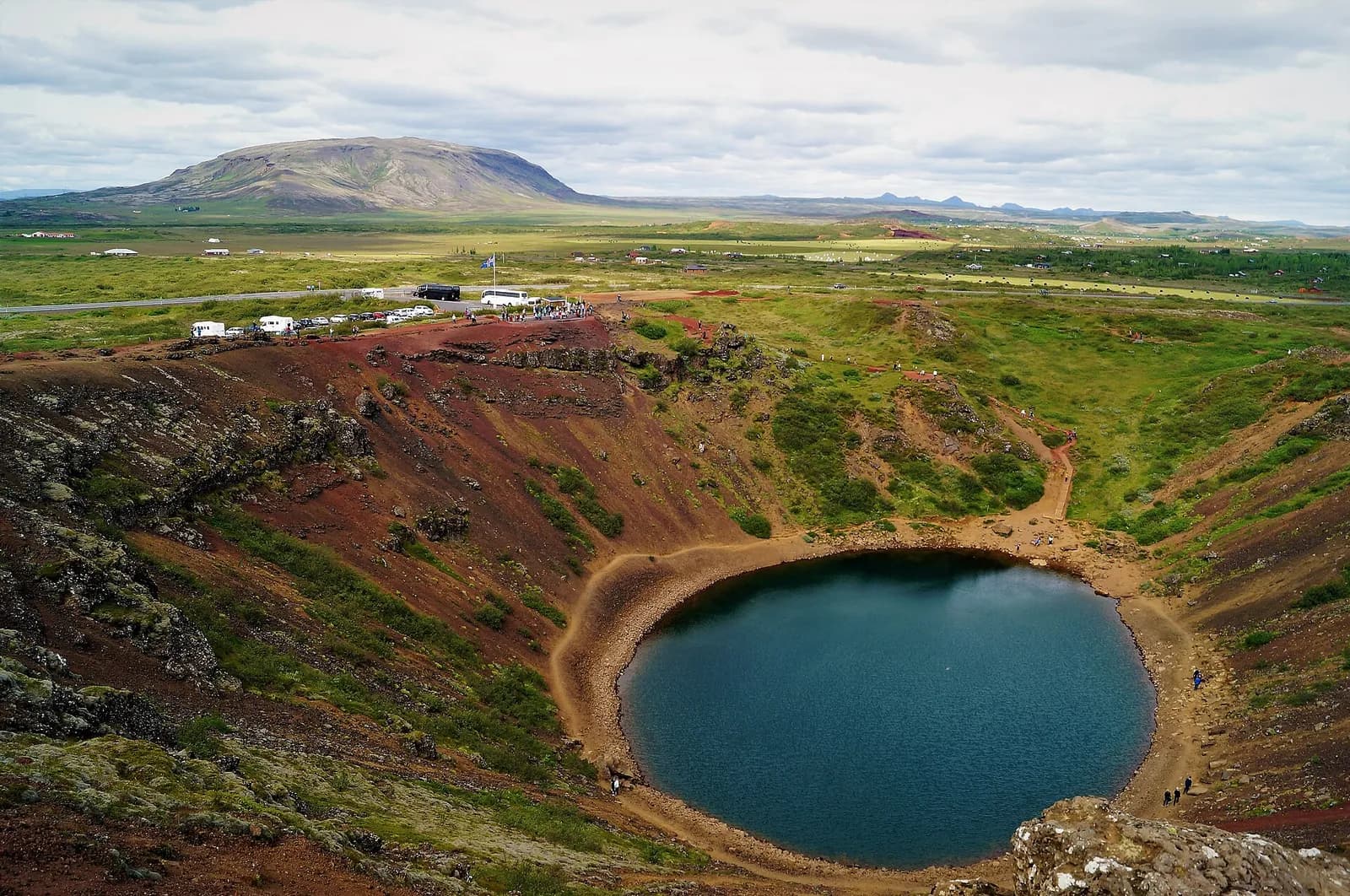 vue plongeante sur le lac du cratère de Kerið depuis le bord, plaine islandaise en arrière-plan