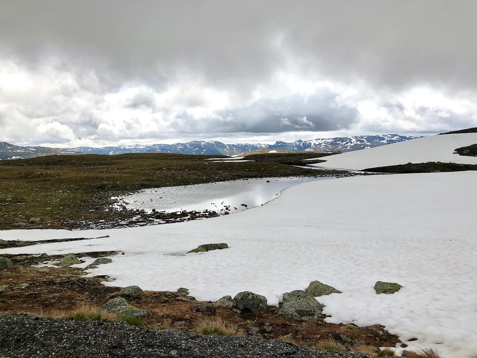 grands névés et lande rase sur le plateau d'Aurlandsfjellet sous un ciel chargé
