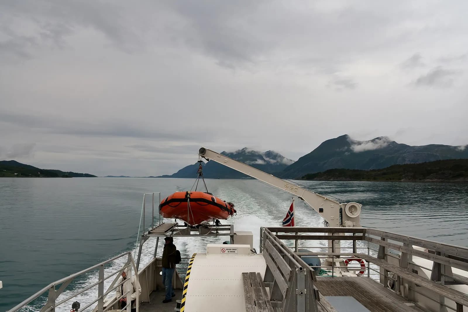 passagers sur le pont avant d'un navire Hurtigruten naviguant vers le glacier Svartisen