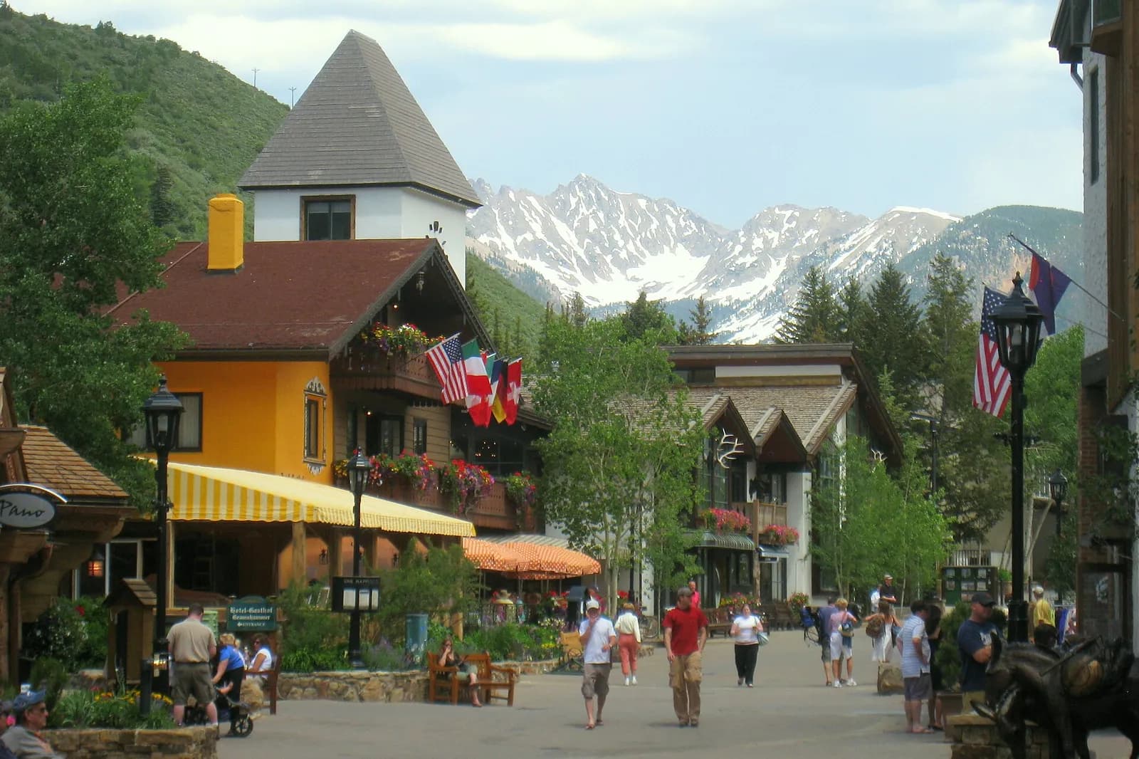 rue piétonne de Vail Village aux chalets de style alpin, avec des sommets enneigés au fond