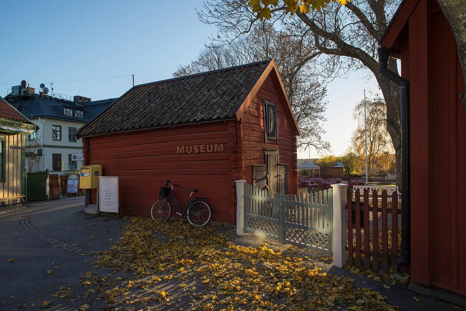 la maison en bois rouge du musée de Sigtuna sous les feuilles d'automne