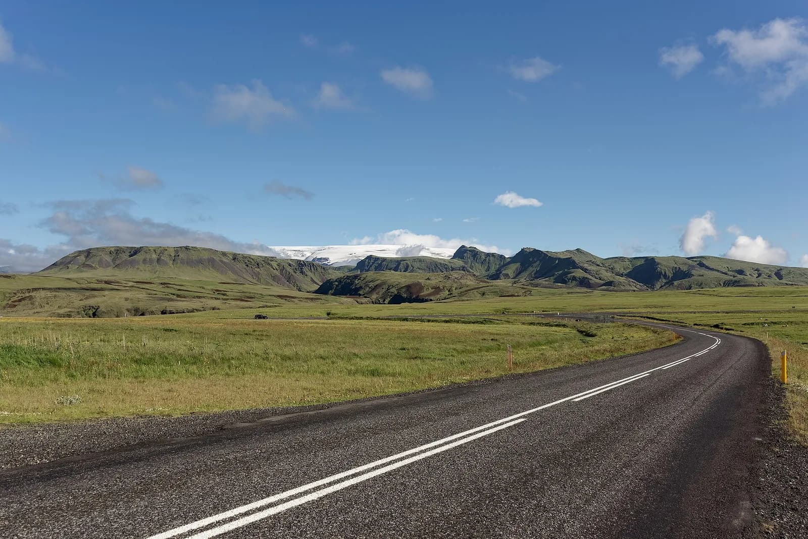 route asphaltée serpentant dans la campagne verdoyante du sud de l'Islande