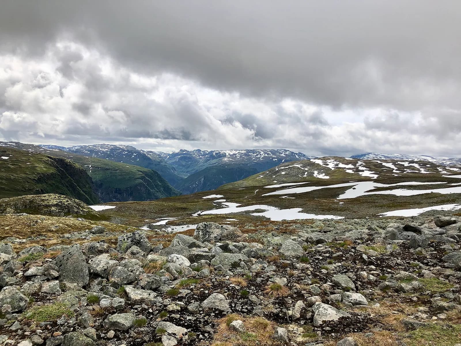 plateau rocheux d'Aurlandsfjellet parsemé de névés, avec les vallées en contrebas