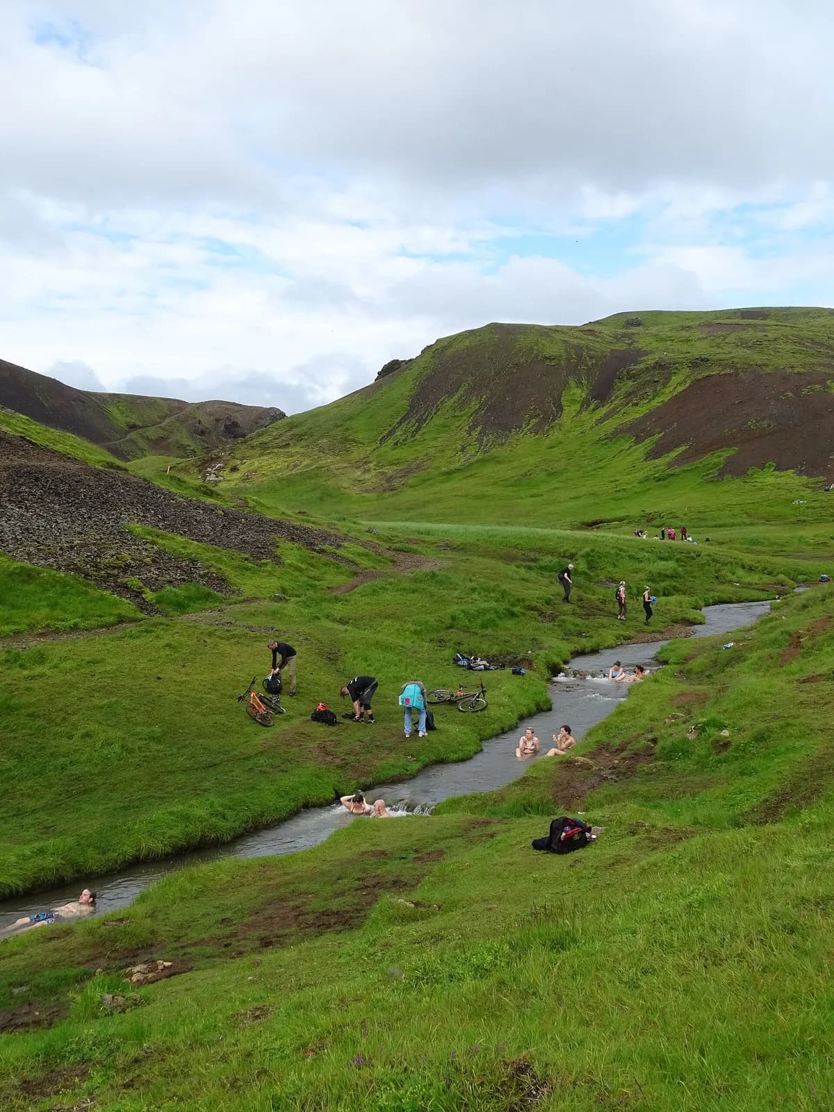 randonneurs se baignant dans la rivière chaude de la vallée de Reykjadalur