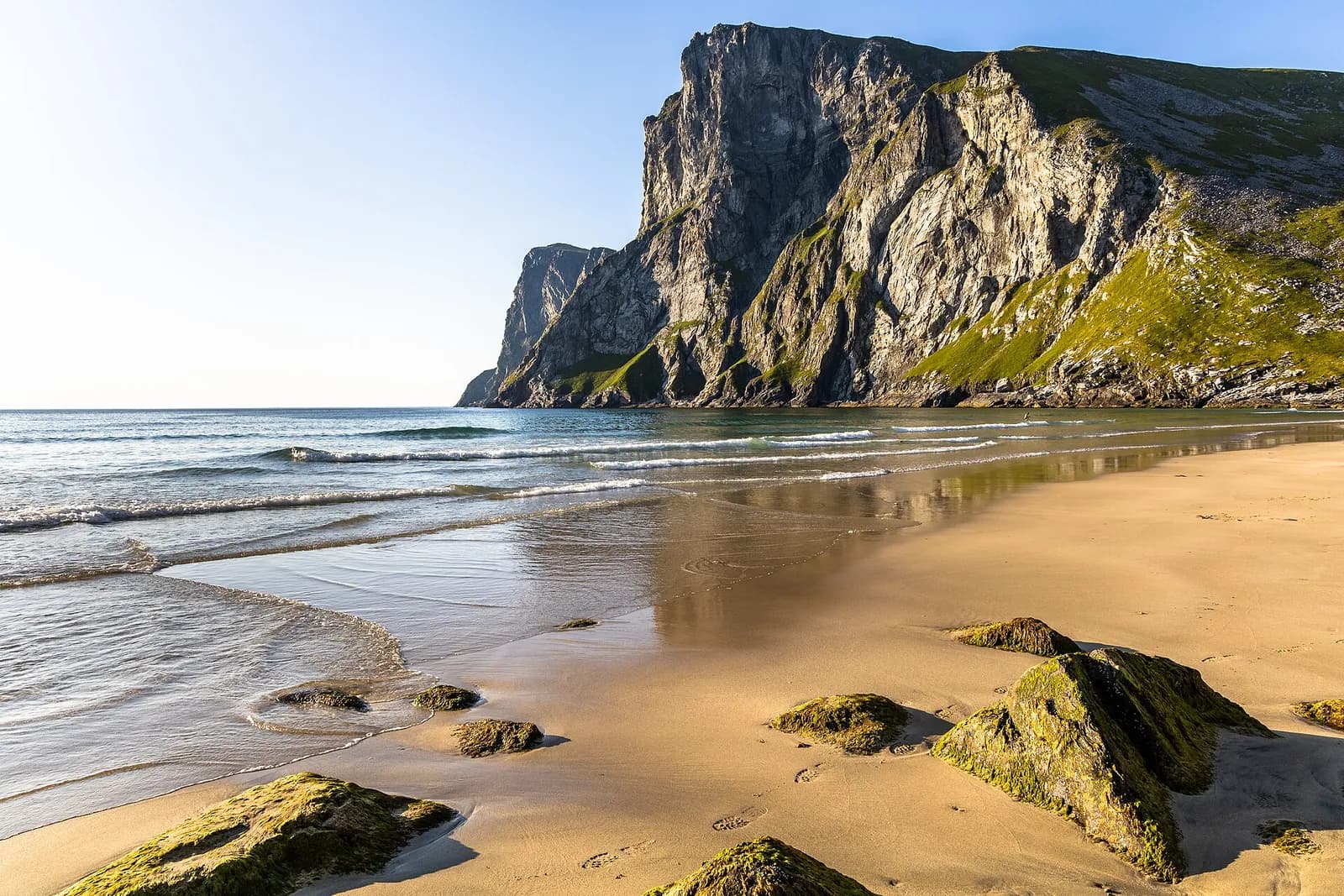 la plage de sable doré de Kvalvika bordée de falaises verdoyantes sur l'île de Moskenesøya