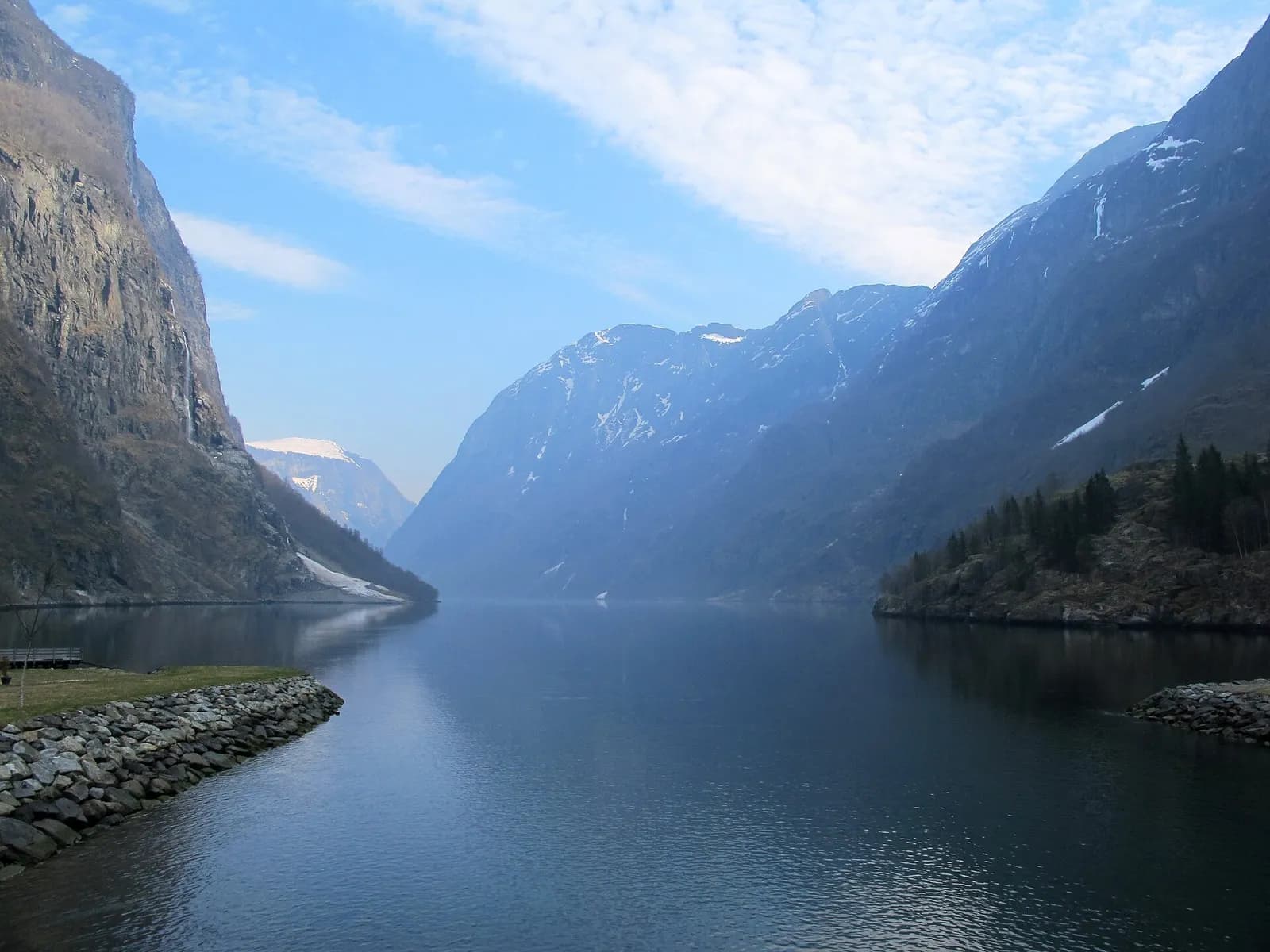 eaux calmes d'un fjord bordé de montagnes aux sommets enneigés