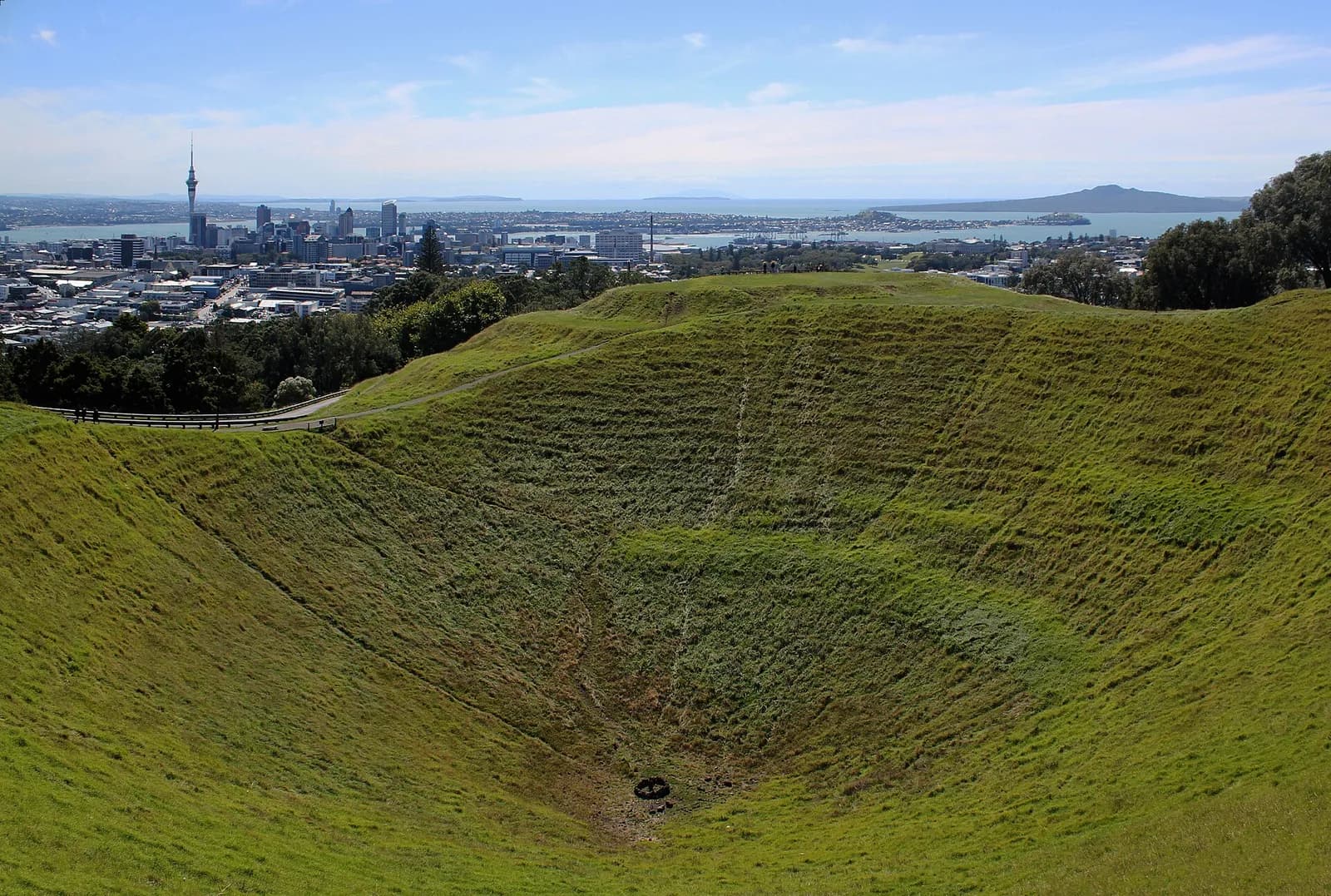 le profond cratère herbeux du mont Eden face au centre d'Auckland et à l'île Rangitoto
