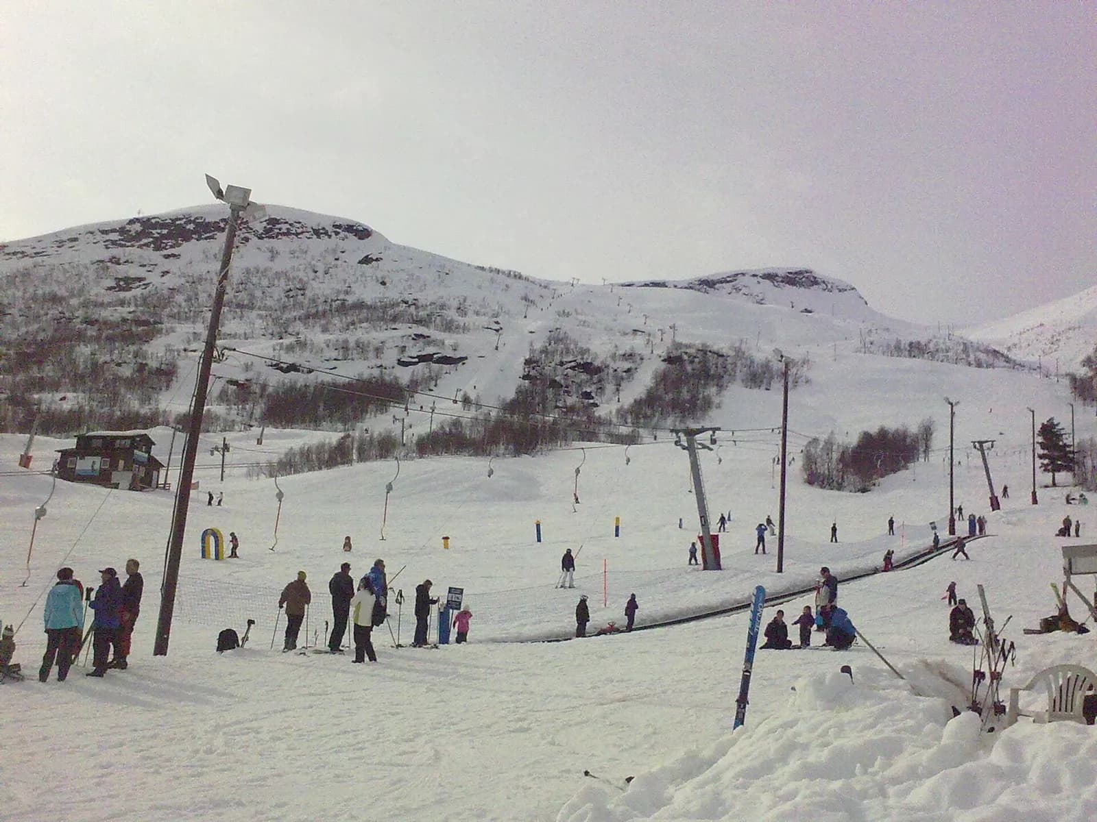 skieurs au pied d'une petite station de ski norvégienne avec son téléski