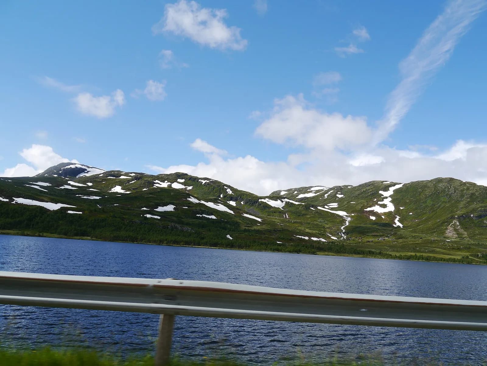 lac de montagne et collines tachetées de neige le long de la route Snøvegen