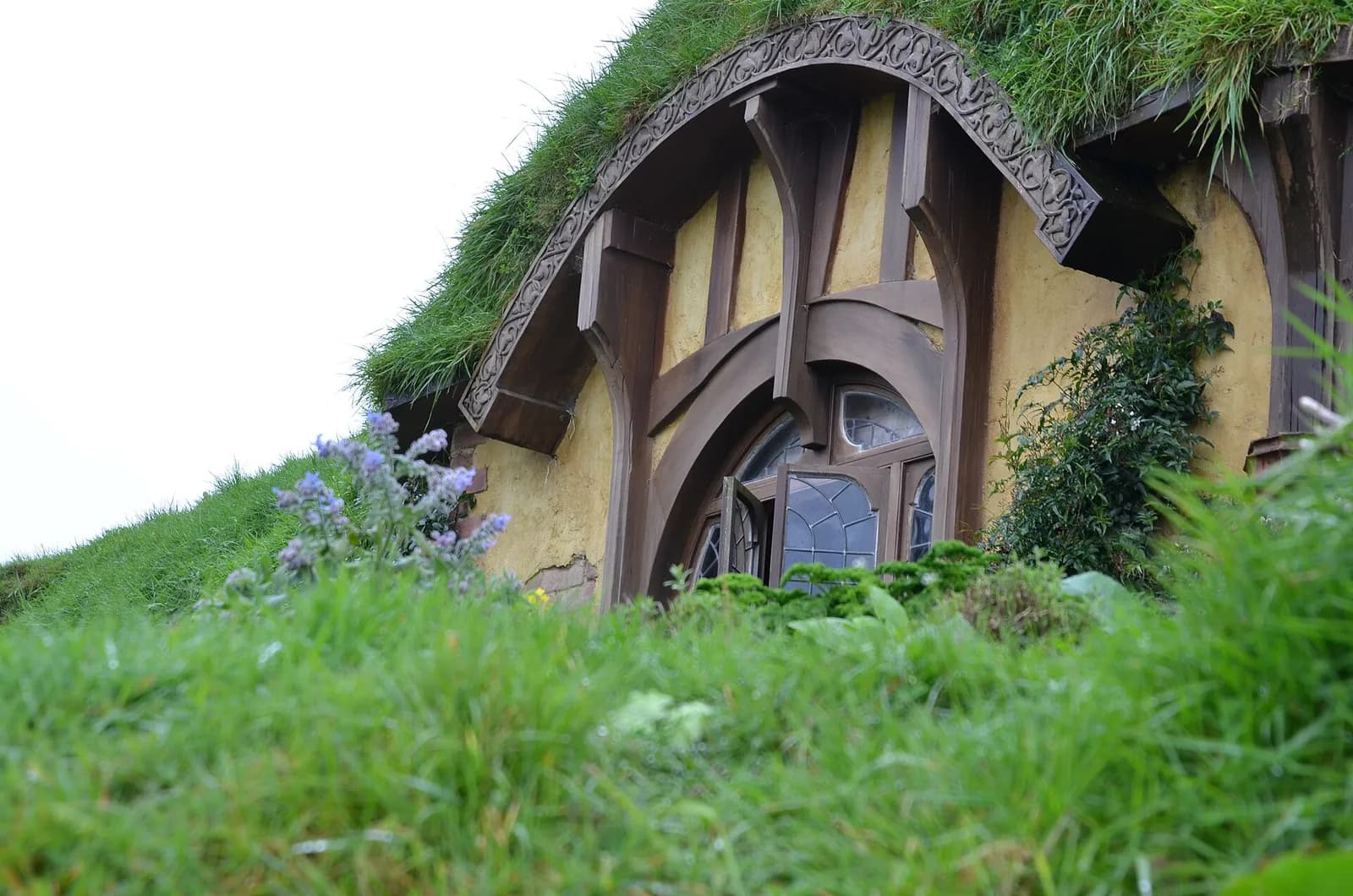 la fenêtre ronde en bois sculpté d'une façade de trou de hobbit à Hobbiton
