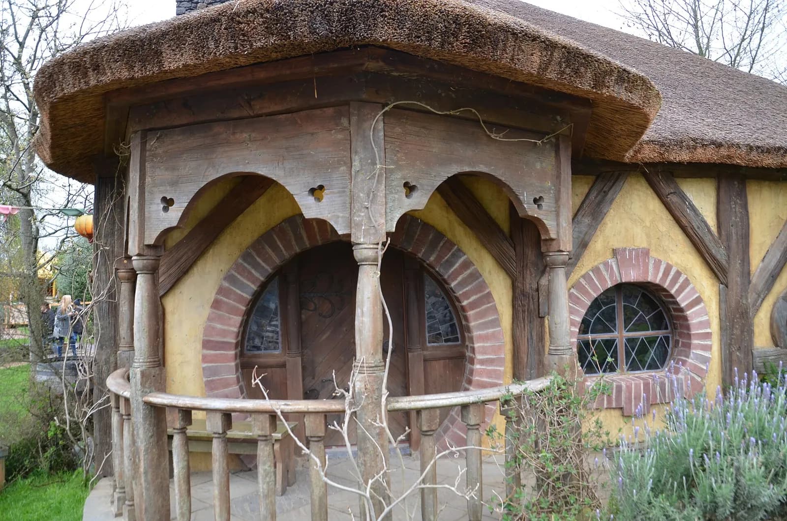 le porche arrondi aux briques colorées d'une maison de hobbit près du Dragon Vert