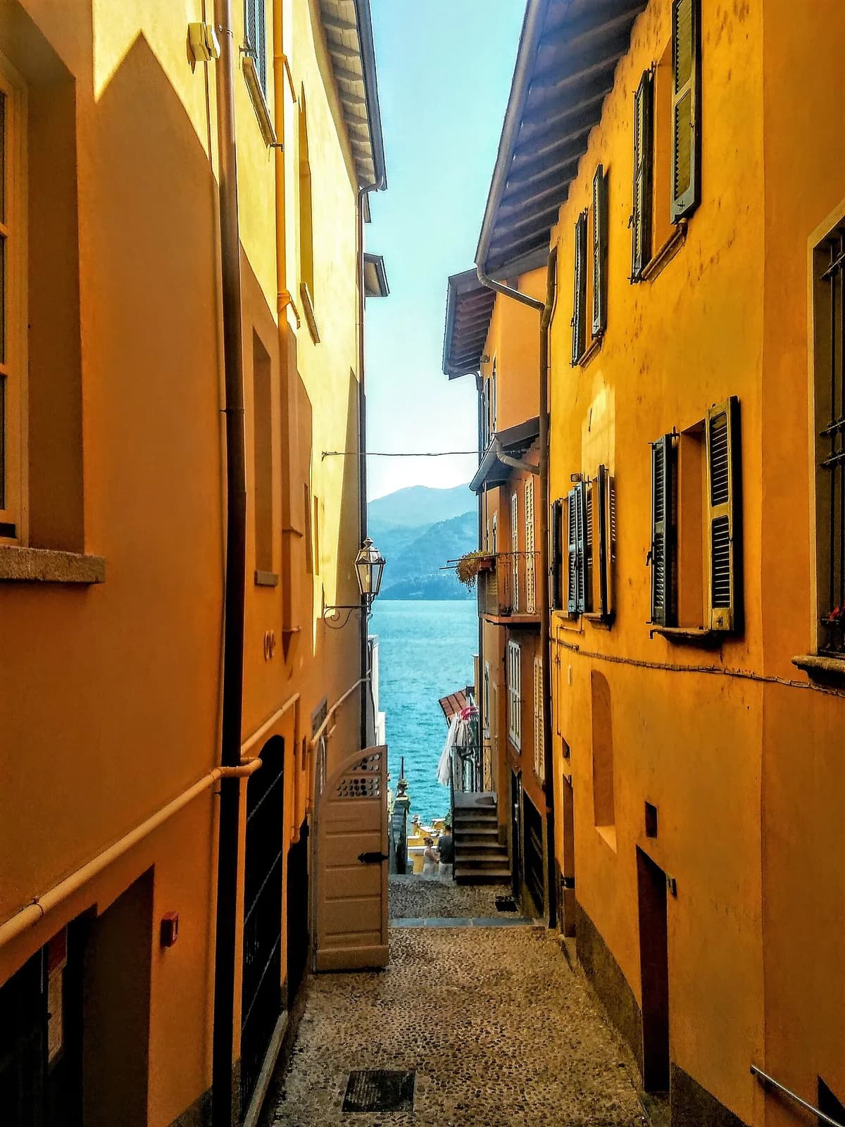 ruelle étroite aux façades ocre de Varenna descendant vers le lac de Côme