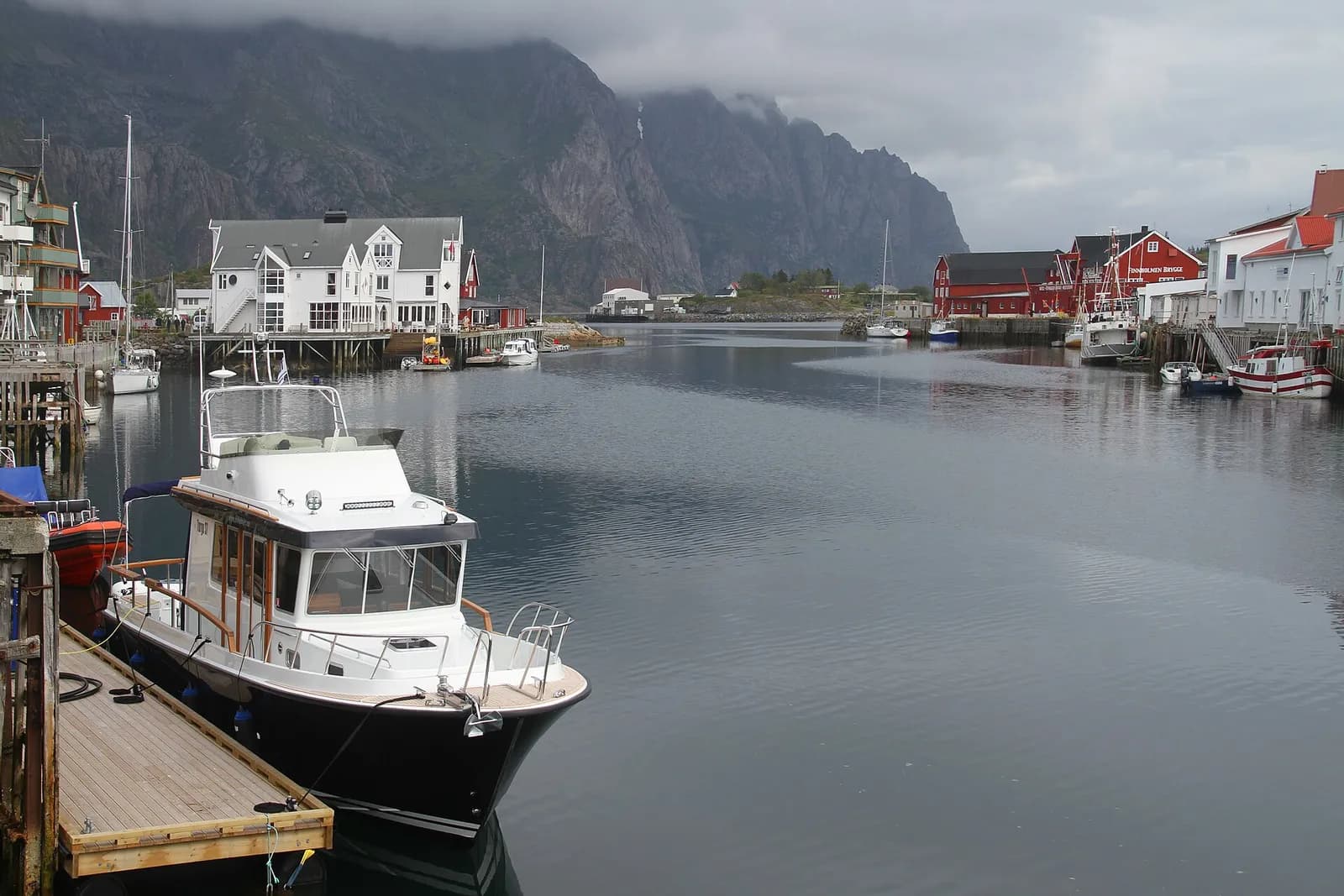 bateau amarré dans le port d'Henningsvær, bordé de maisons en bois