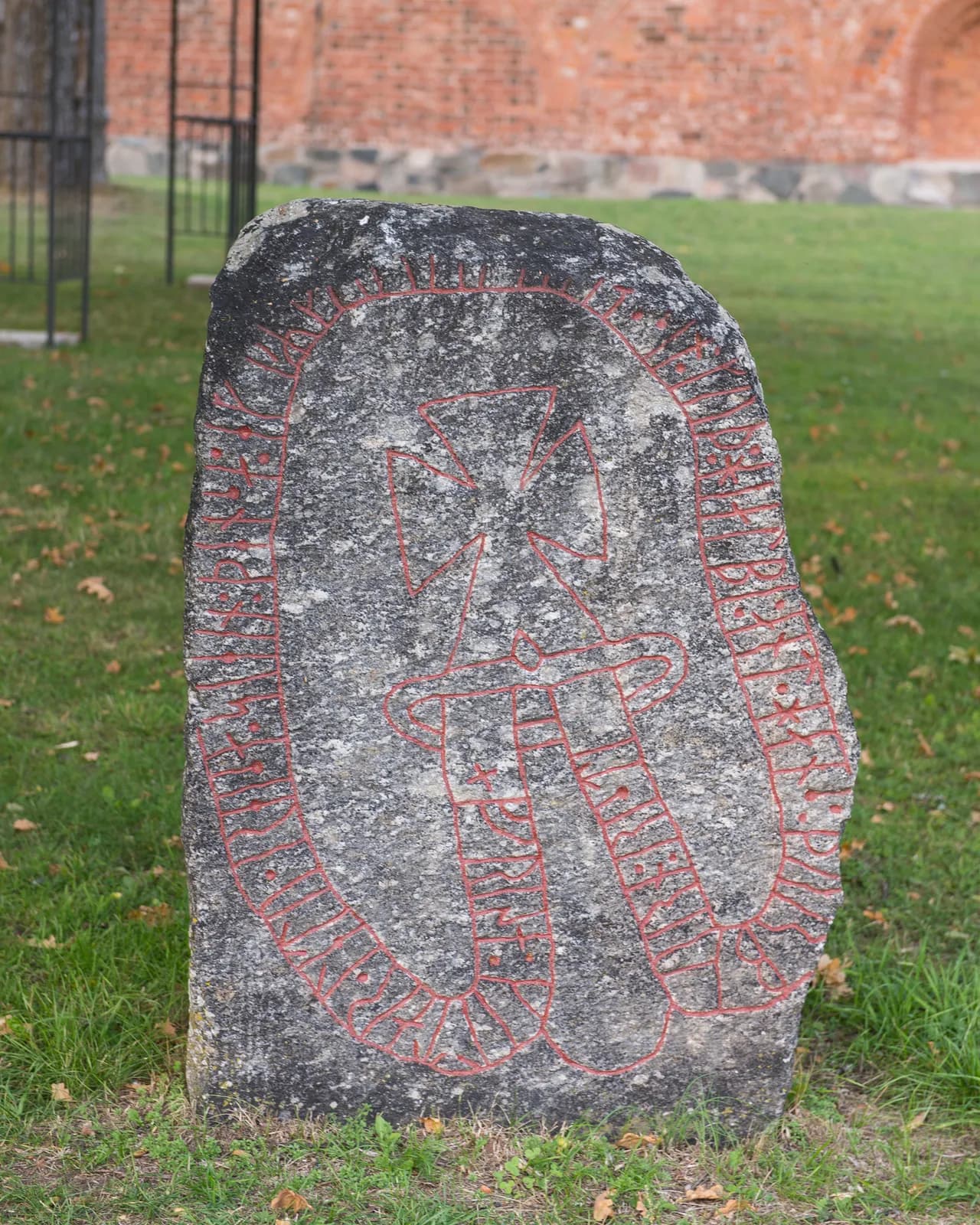 pierre runique U379 aux inscriptions peintes en rouge sur une pelouse de Sigtuna