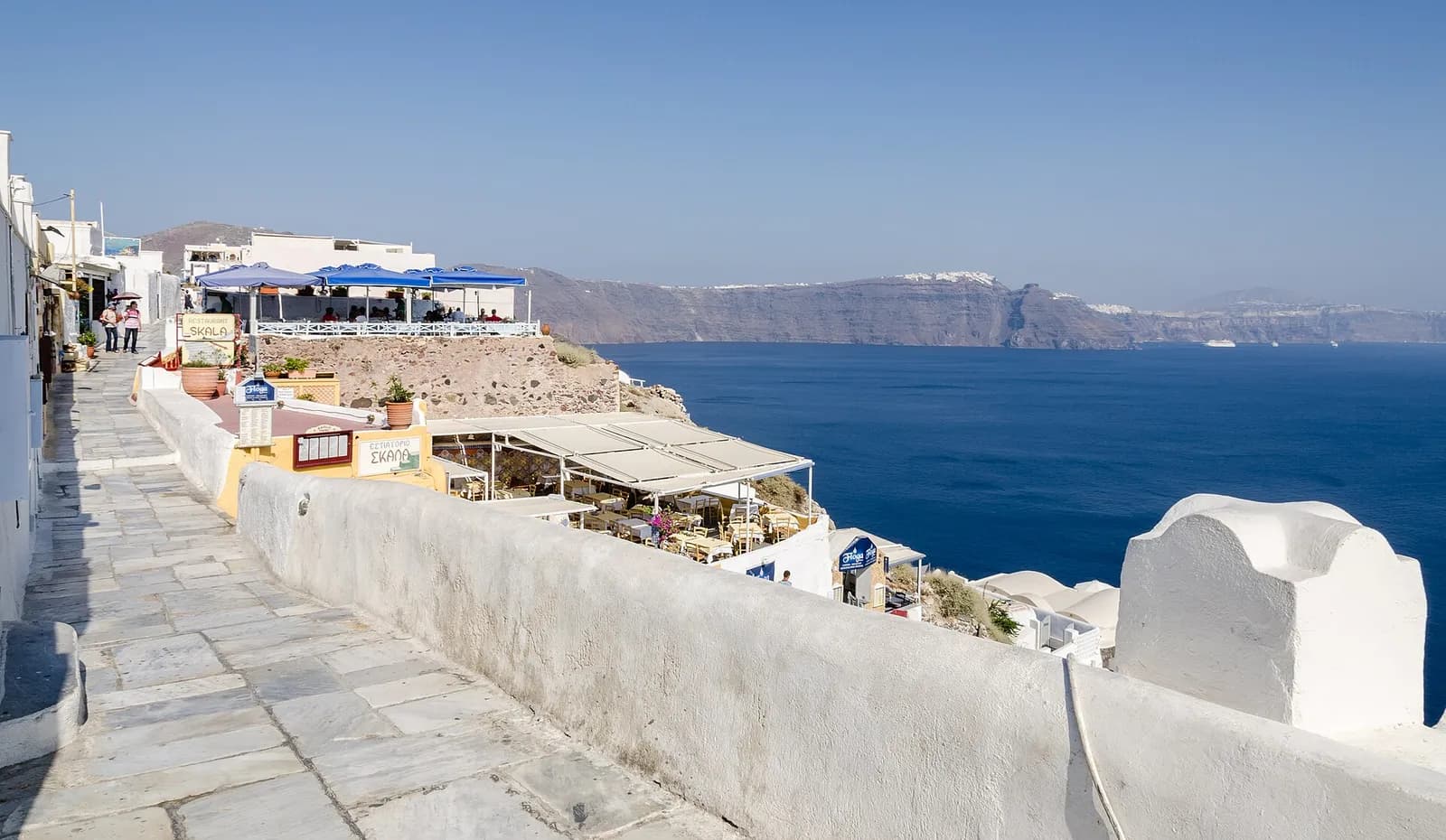 terrasses de cafés et restaurants accrochées au bord de la caldeira à Oia, face à la mer Égée