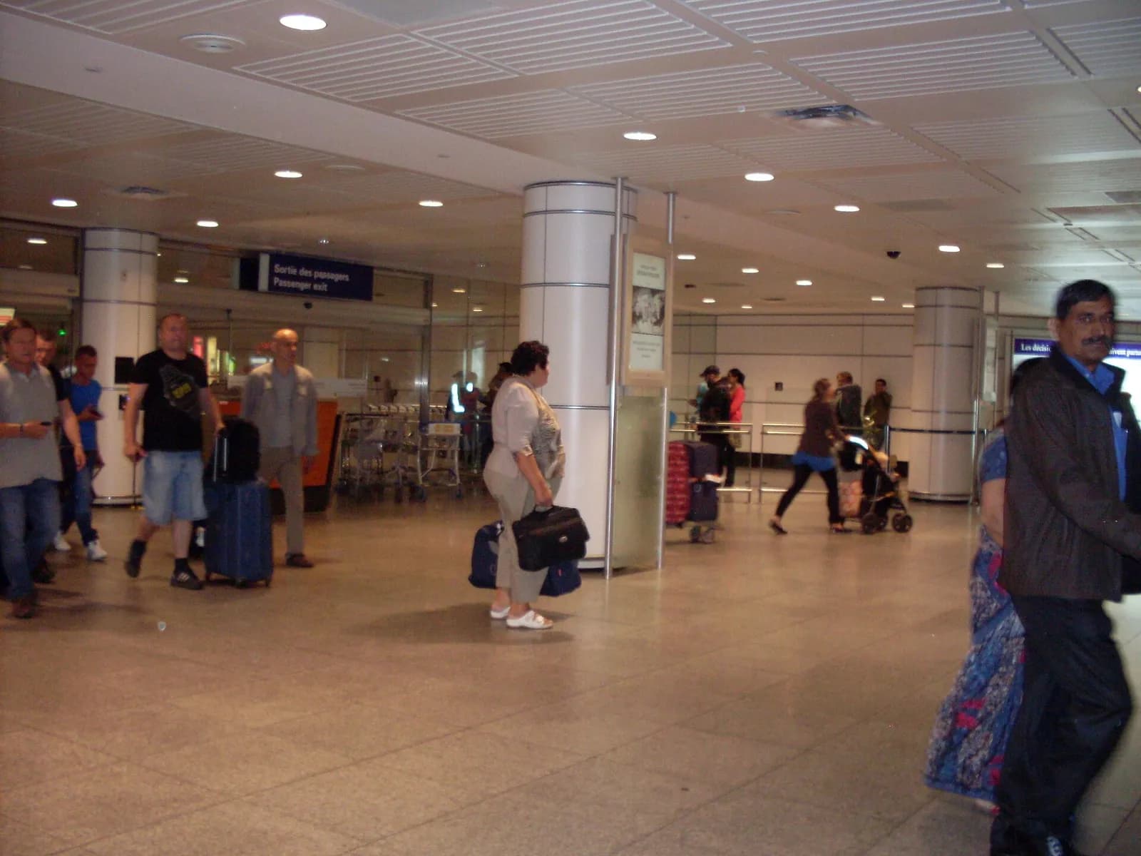 voyageurs et valises dans le hall des arrivées internationales de l'aéroport Montréal-Trudeau