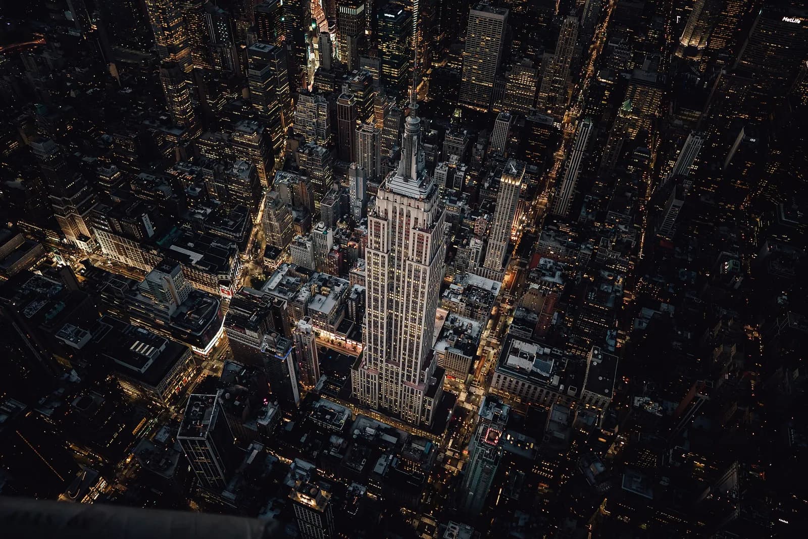 vue aérienne nocturne de l'Empire State Building illuminé au milieu de Manhattan