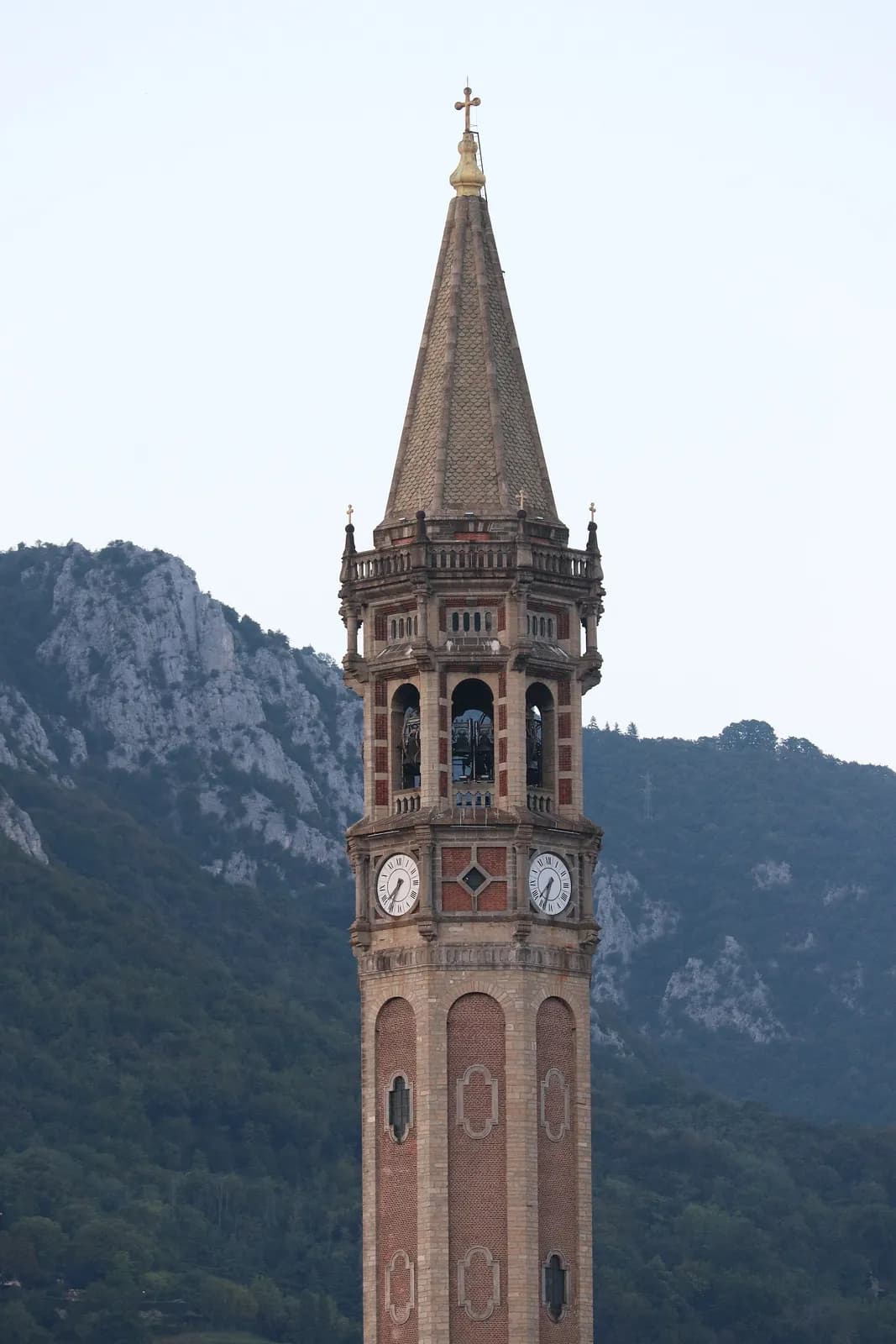 le haut campanile de la basilique San Nicolò de Lecco devant les parois rocheuses