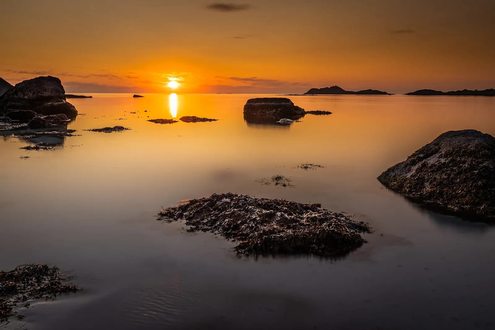 rochers se découpant dans la lumière dorée du soleil de minuit sur la plage de Ramberg