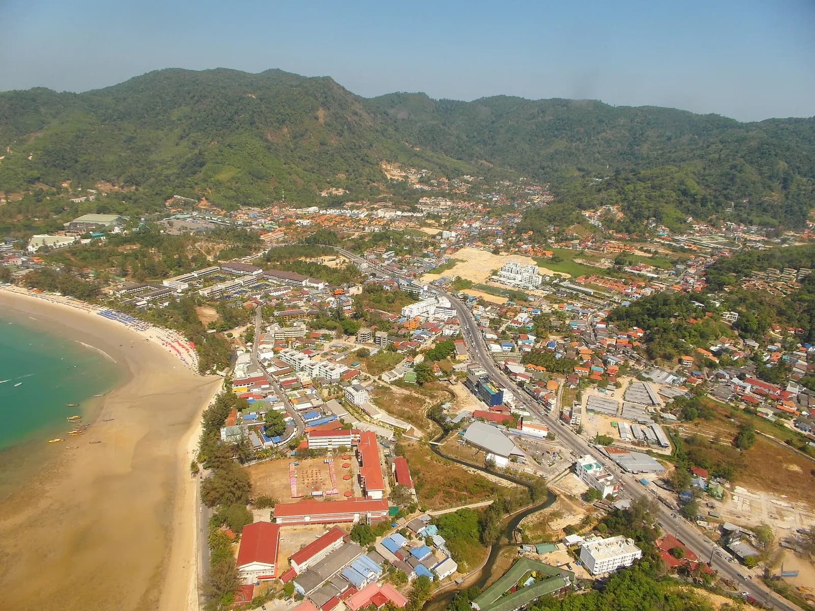 la baie de Kamala et son village vus du ciel, entre mer et collines verdoyantes